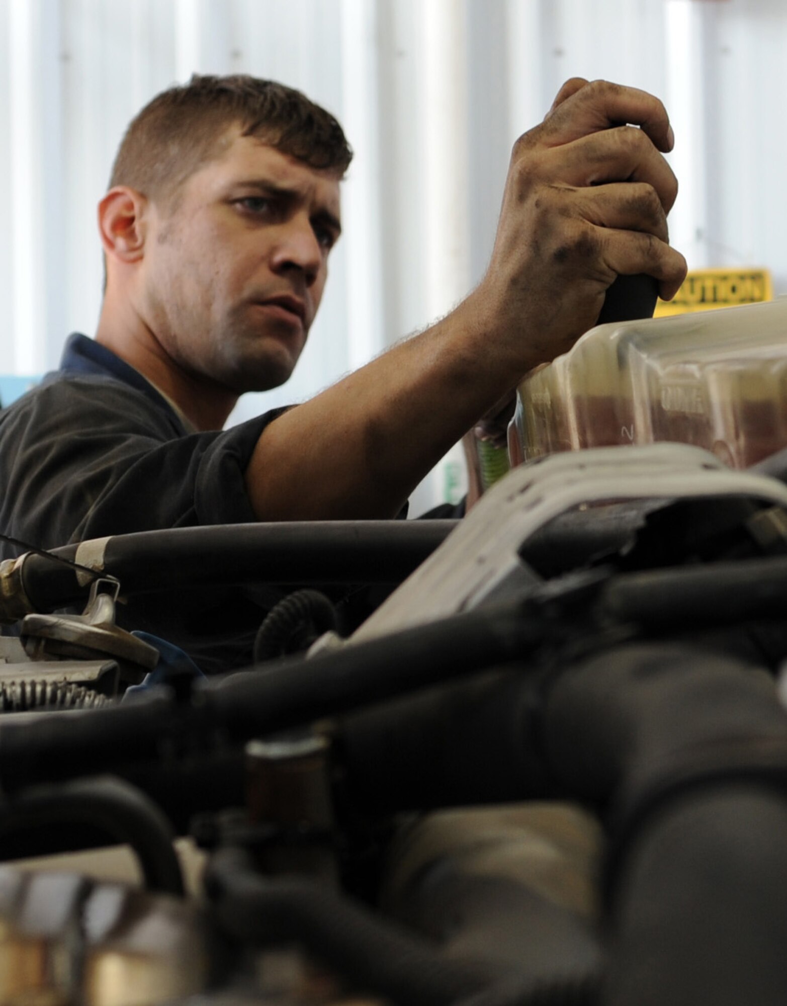 U.S. Air Force Staff Sgt. Patrick Stroschein, 366th Logistics Readiness Squadron material handling maintenance journeyman, adjusts a transmission fluid valve Aug. 26, 2013, at Mountain Home Air Force Base, Idaho. Vehicle maintainers have the unique responsibility of supporting both the ground and air missions. (U.S. Air Force photo by Senior Airman Benjamin Sutton/Released)