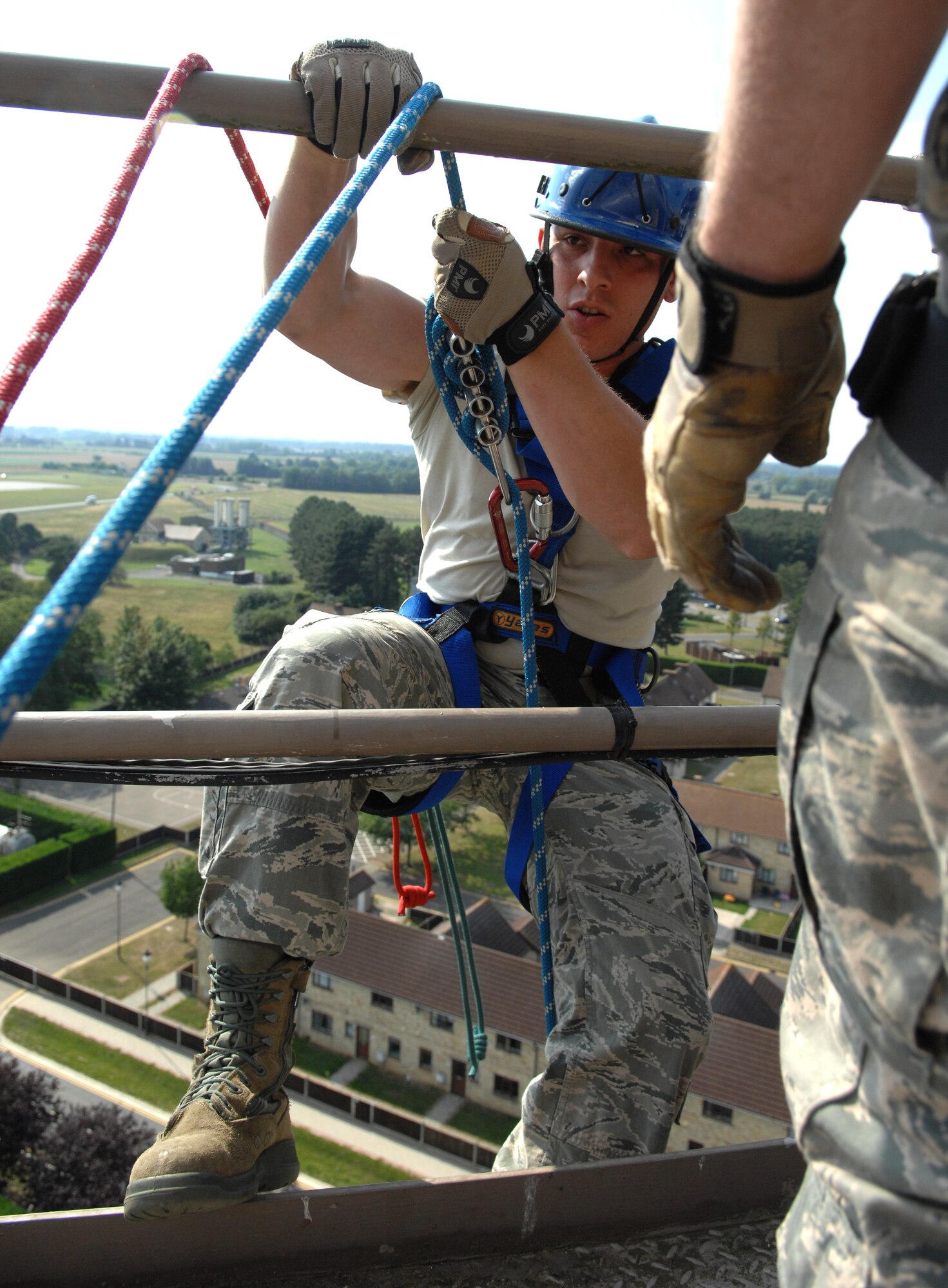 U.S. Air Force Airman 1st Class Jacob Dietmeyer, 100th Civil Engineer Squadron Fire Department firefighter from Gurnee, Ill., climbs the railing of a water tower before rappelling Sept. 4, 2013, on RAF Mildenhall, England. Rappelling involves at least two people, one of which performs the actual rappelling, while the other feeds a safety line down in case the person rappelling begins to fall. The water tower from which the firefighters rappelled is 118 feet tall, almost three stories higher than what the firefighters normally train on. (U.S. Air Force photo by Airman 1st Class Dillon Johnston/Released)