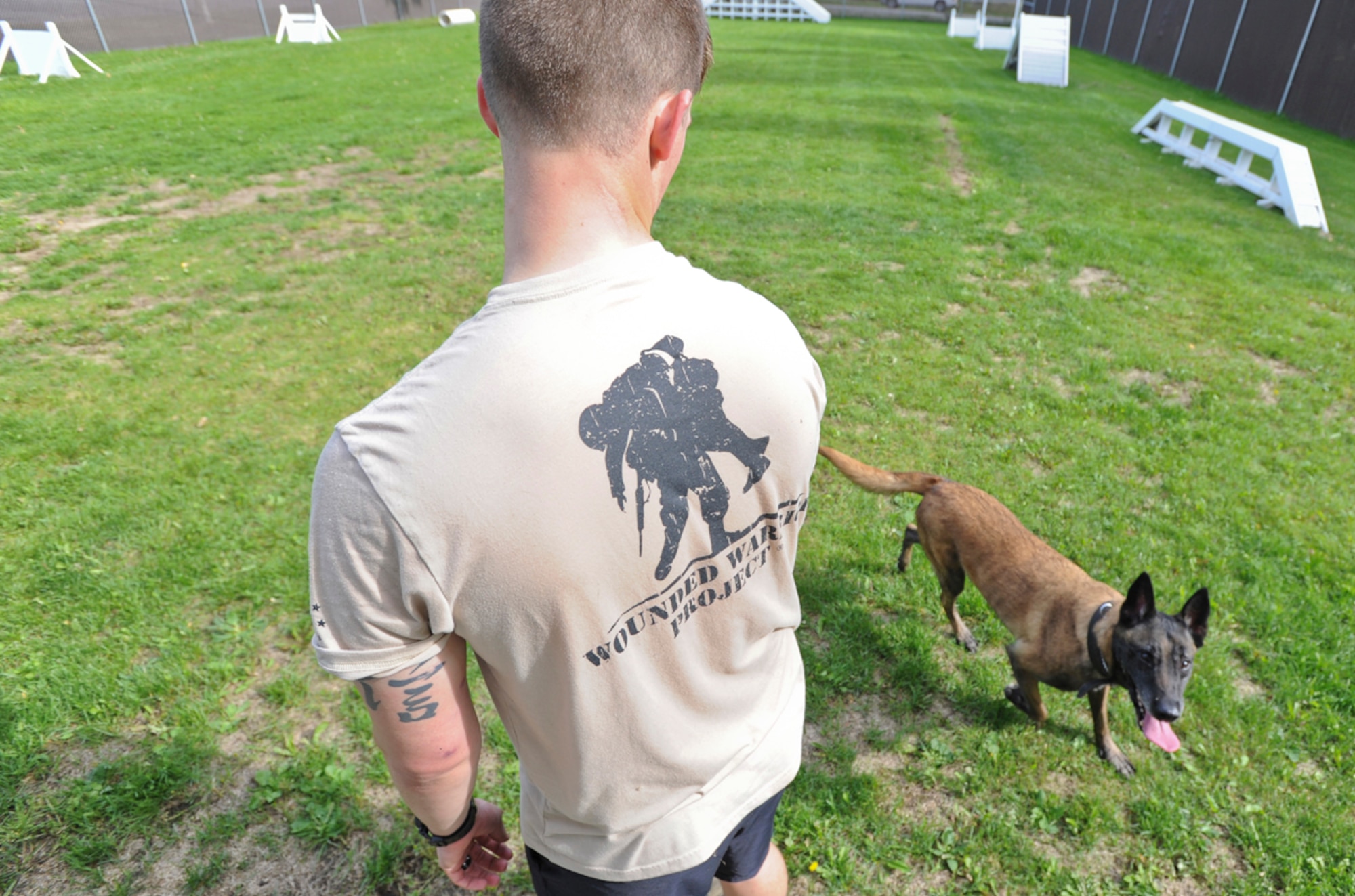 Senior Airman Shawn Witcher, assigned to the 673d Air Base Wing Security Forces Squadron, a native of Mesquite, Texas, looks at Kimba, a military working dog, playfully trotting around him after a training session on Joint Base Elmendorf-Richardson, Aug. 26, 2013. Security Forces Airmen continually train with their K9 counterparts to keep their teams flexible to respond to law enforcement emergencies, and for overseas deployments.  (U.S. Air Force photo by Justin Connaher/Released)