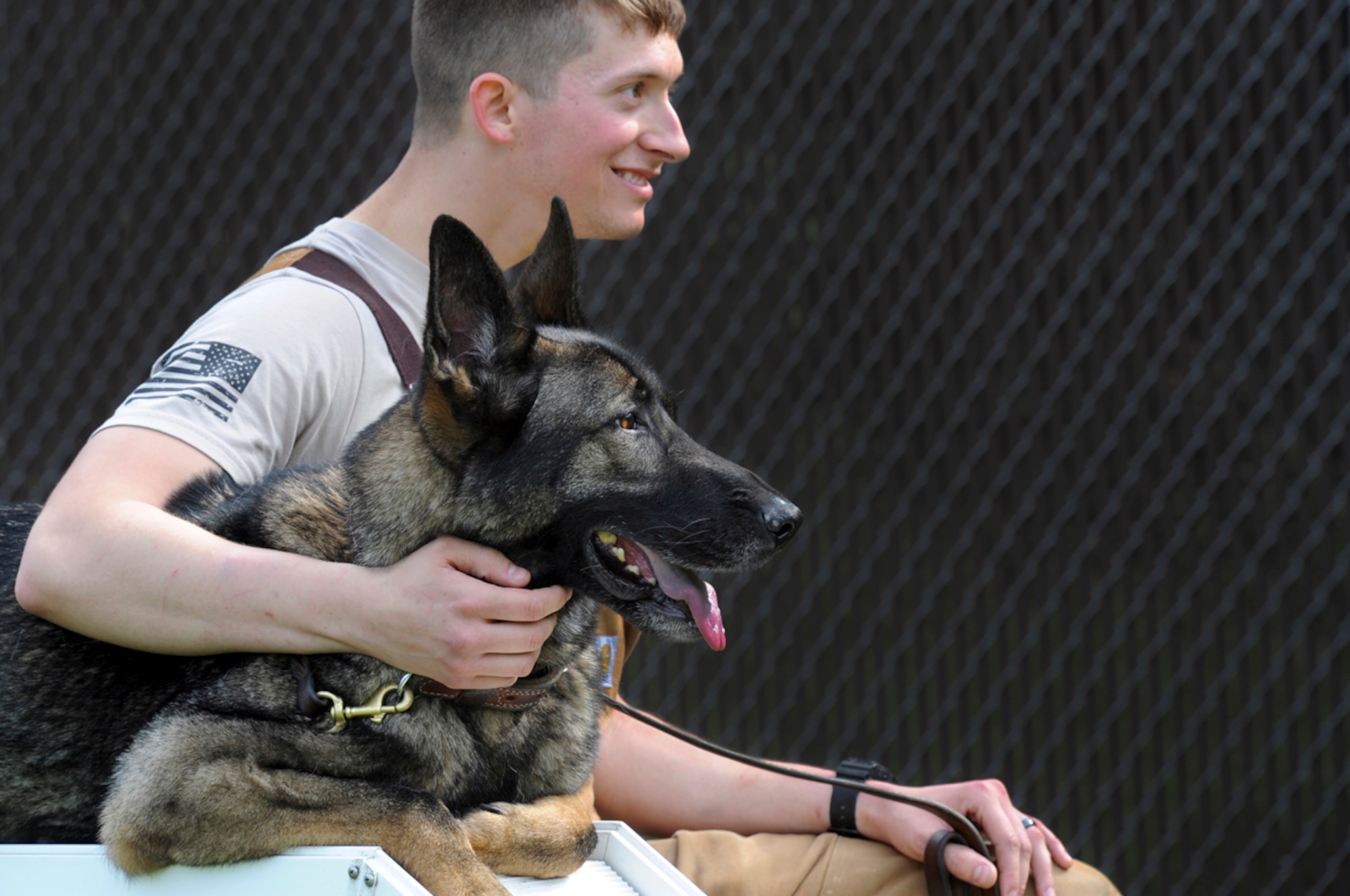 Senior Airman Shawn Witcher, assigned to the 673d Air Base Wing Security Forces Squadron, a native of Mesquite, Texas, sits with his military working dog Ajax, a German shepherd, after a training session on Joint Base Elmendorf-Richardson, Aug. 26, 2013. Security Forces Airmen continually train with their K9 counterparts to keep their teams flexible to respond to law enforcement emergencies, and for overseas deployments.  (U.S. Air Force photo by Justin Connaher/Released)
