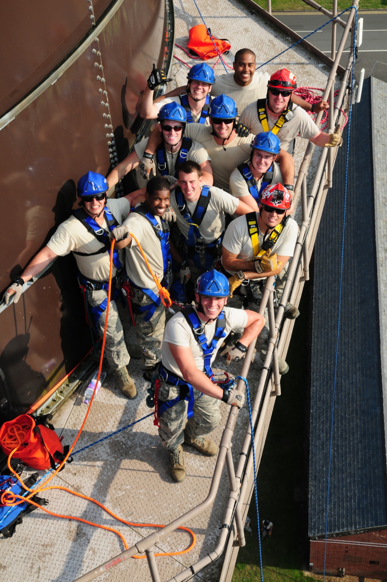Firefighters from the 100th Civil Engineer Squadron Fire Department, along with two instructors from the 435th Construction and Training Squadron, Ramstein Air Base, Germany, take a break after performing technical rope rescue training from the top of 120-foot water towers Sept. 4, 2013, on RAF Mildenhall, England. An average of four rescue classes are conducted per year at the CTS site in Ramstein, and two mobile classes per year are held throughout U.S. Air Forces in Europe. In addition to the high-angle rescue training, firefighters also learned techniques including incident management system, ground support for helicopter systems and operational risk management. (U.S. Air Force photo by Karen Abeyasekere/Released)