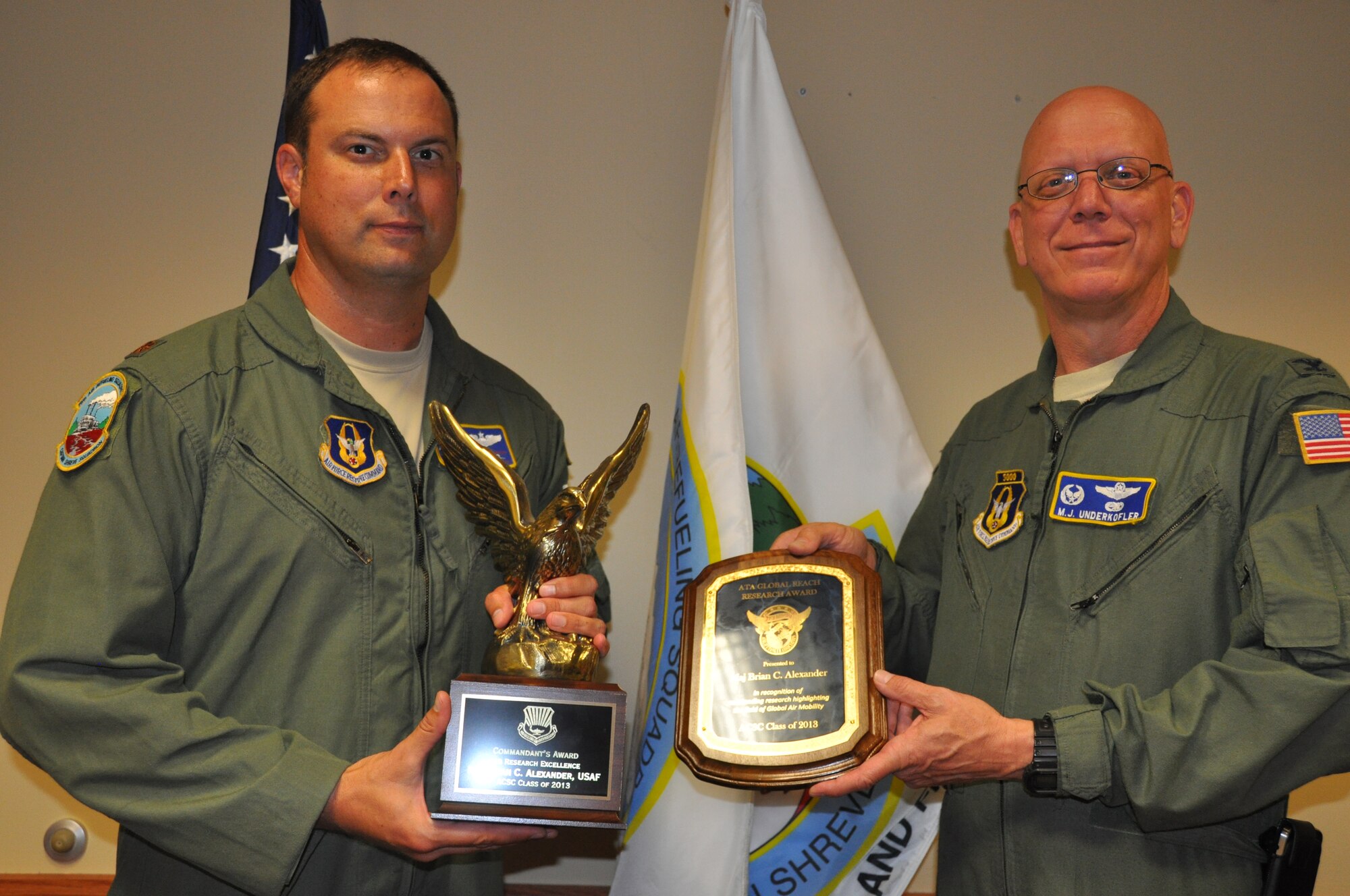 Col. Michael Underkofler, 514th Air Mobility Wing commander, congratulates Maj. Brian Alexander, 78th Air Refueling Squadron KC-10 Extender pilot, for receiving the Air Command and Staff College’s commandant’s award for excellence in research here Aug. 25. Alexander, spent 16 weeks completing his research paper while in pursuit of his master’s degree from Air Command and Staff College (U.S. Air Force photo/Senior Airman Chelsea Smith).