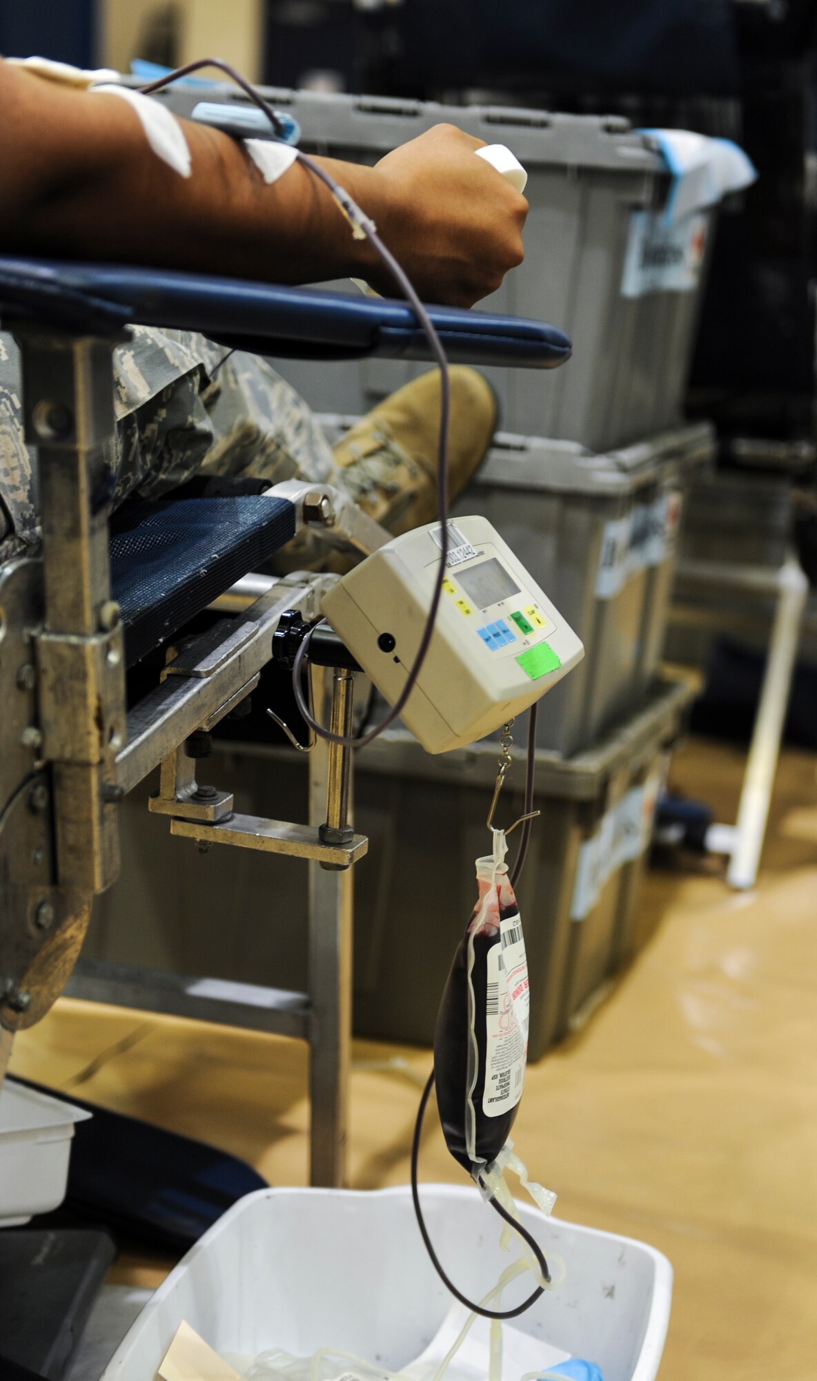 An Airman sits while donating blood at Moody Air Force Base, Ga., Sept. 4, 2013. The bag is hanging from a scale that weighs the bag as it fills. When the bag gets full, the machine beeps to let the technicians know it has reached the maximum weight. (U.S. Air Force photo by Air man Alexis Grotz/Released)