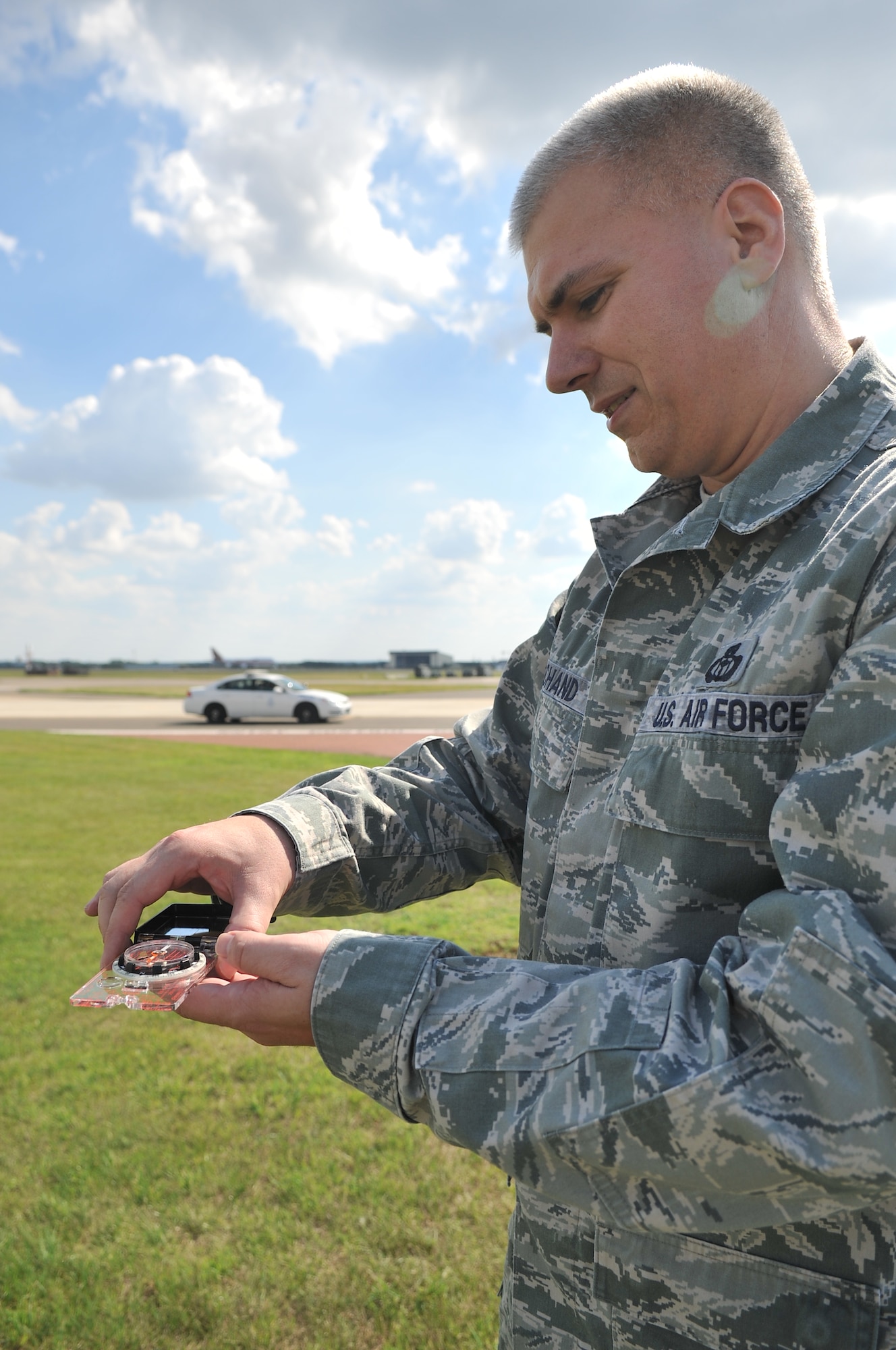 U.S. Air Force Master Sgt. Keith Bachand, 100th Operations Support Squadron weather forecaster from Canterbury, Conn., uses a compass to determine the direction in which a solar panel on a weather sensor points Aug. 26, 2013, on RAF Mildenhall, England. Bachand takes part in a routine training exercise to ensure the backup tactical meteorological observing sensor functions properly. For the most effective reading, the solar panel needs to point south. (U.S. Air Force photo by Airman 1st Class Kyla Gifford/Released)