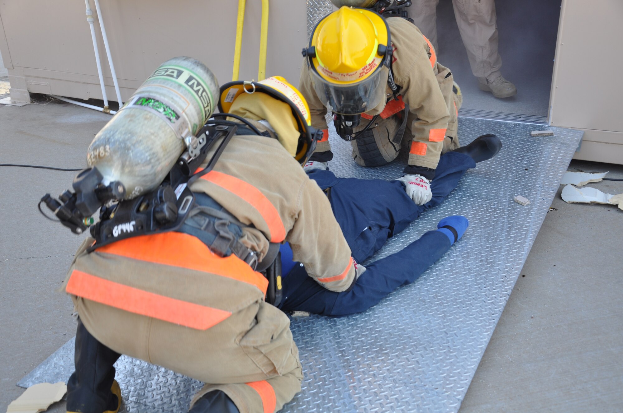 GOODFELLOW AIR FORCE BASE, Texas- 312th Training Squadron students pull a dummy body out of the newest structural fire trainer at the Defense Department Louis F. Garland Fire Academy during the trainer dedication Aug. 30. The students demonstrated to the dedication attendees the types of training the structural trainer supports. (U.S. Air Force photo/ Airman 1st Class Erica Rodriguez)