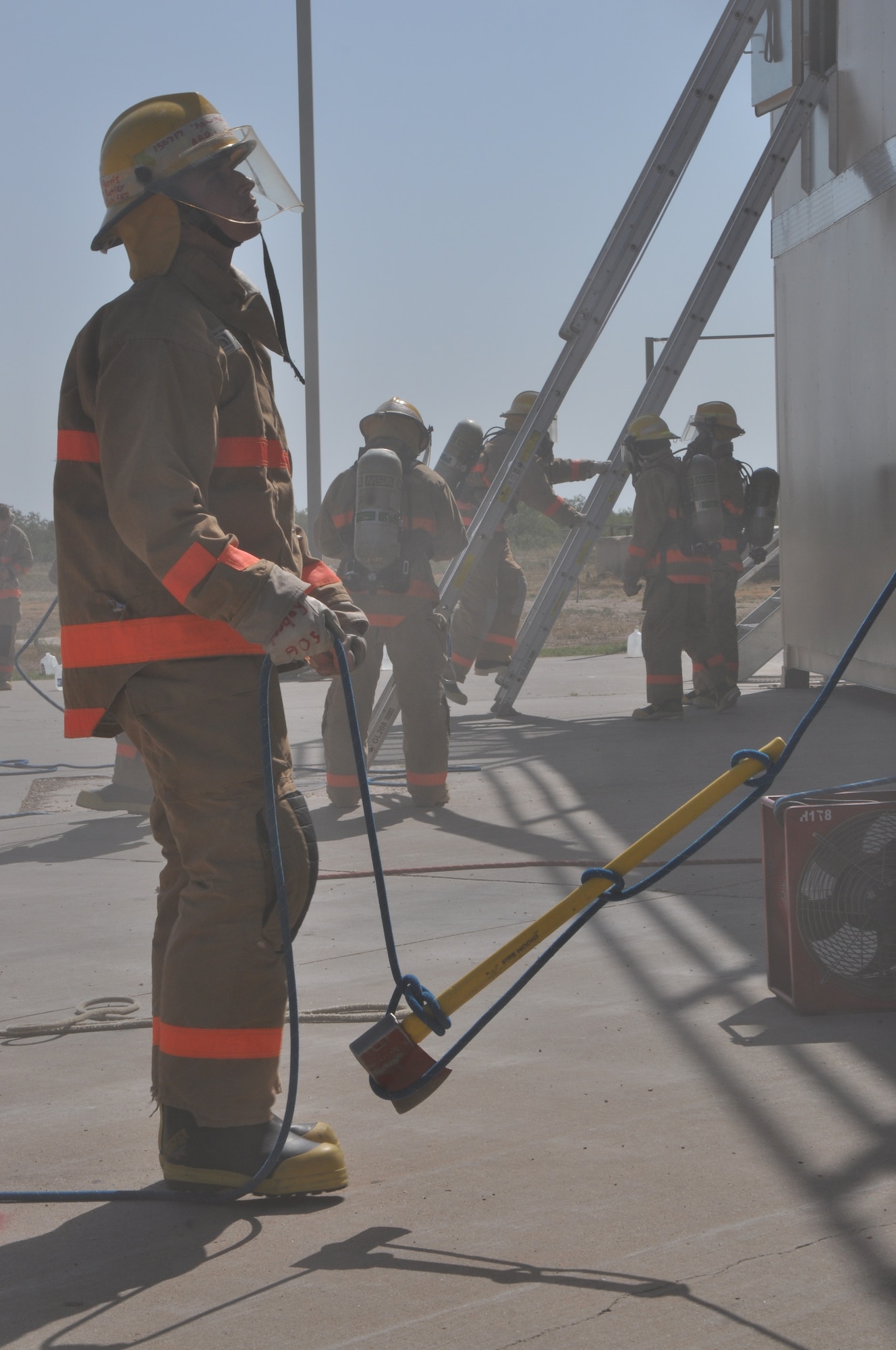 GOODFELLOW AIR FORCE BASE, Texas – Airman Tyler Roberts, 312th Training Squadron student, stabilizes an ax he tied to a rope while other students bring the tool to the top of the trainer, after the 312th Training Squadron new firefighter trainer dedication Aug. 30. Roberts and other students also demonstrated ladder climbs and search and rescue exercises. (U.S. Air Force photo/ Airman 1st Class Joshua Edwards)