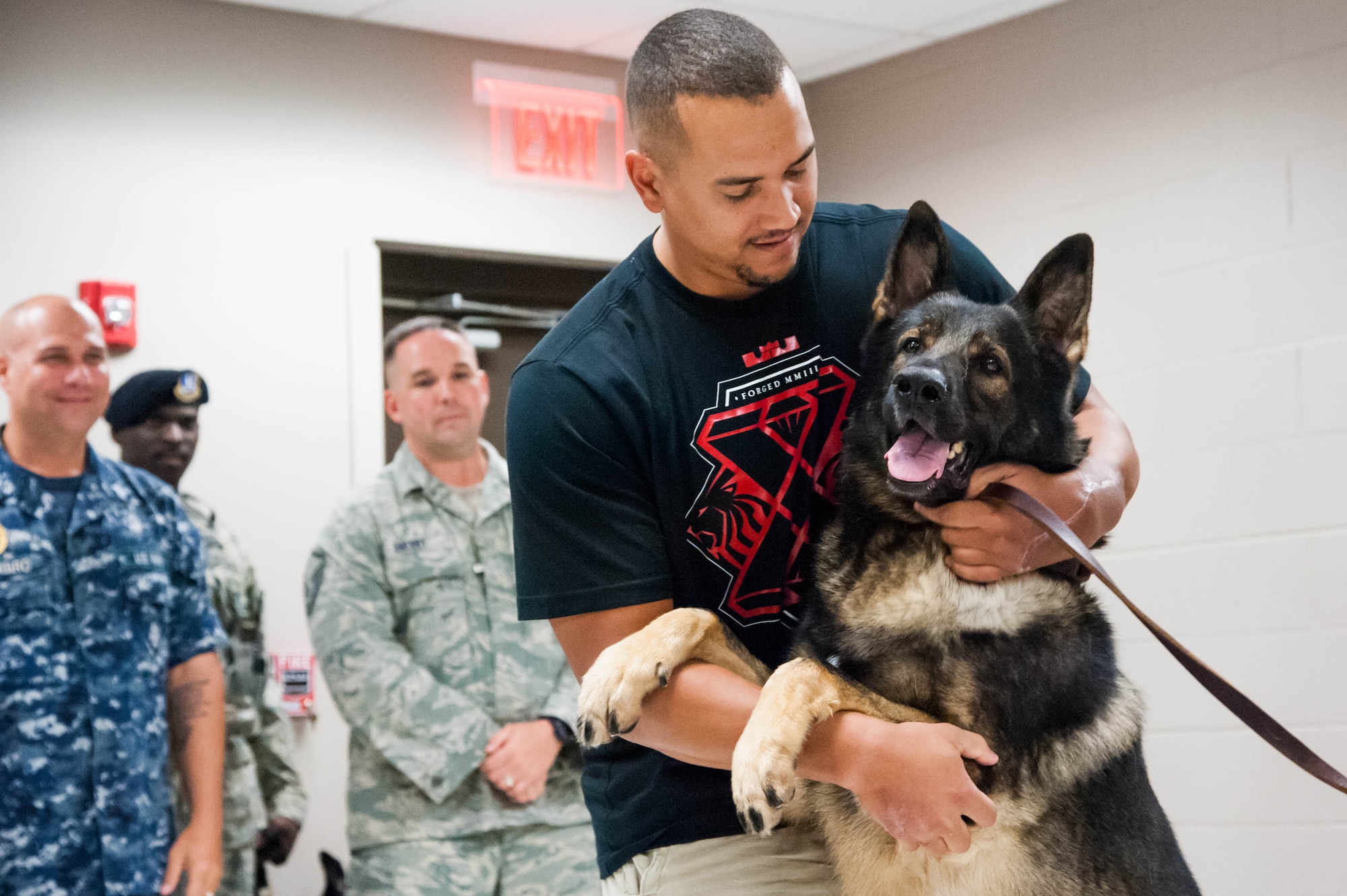Staff Sgt. Brian Williams, 87th Security Forces Squadron military working dog handler, embraces Carly, his former military working dog, Aug. 28, 2013, on Joint Base McGuire-Dix-Lakehurst, N.J. Williams, who hails from Sierra Vista, Ariz., recently received approval to adopt Carly. Both Williams and Carly deployed in 2011 to Kandahar, Afghanistan where Williams sustained injuries from an improvised explosive device. Service members from the joint base and Carly visited Williams numerous times during his recovery at Walter Reed National Military Medical Center, D.C. (U.S. Air Force photo by Russ Mereroll/Released)


