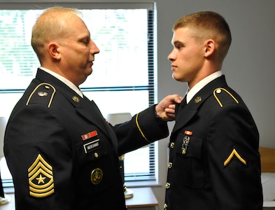 U.S. Army Command Sgt. Maj. Russell Merchant, 1-222nd Aviation Regiment, 1st Battalion command sergeant major, inspects the uniform of Pvt. Steven West, 1-222nd Avn. Rgt. UH-60 Blackhawk crew chief student, at Fort Eustis, Va., Aug. 30, 2013. During down time students have access to a computer cafe and common rooms complete with pool tables and ping-pong tables. (U.S. Air Force photo by Staff Sgt. Wesley Farnsworth/Released)