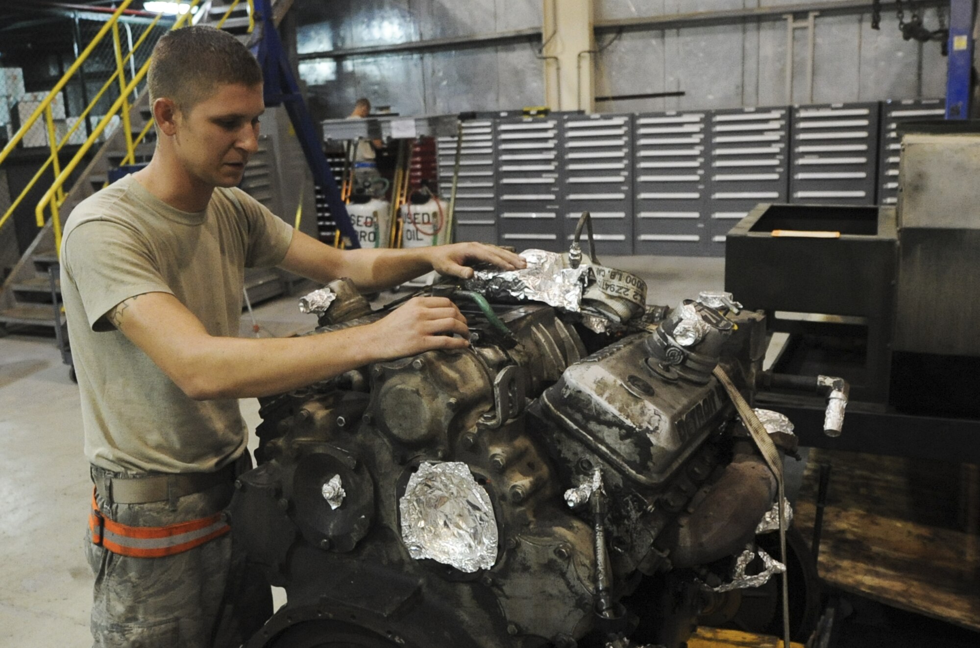U.S. Air Force Staff Sgt. Kyle Anderson, 380th Expeditonary Maintenance Squadron aerospace ground equipment craftsman, looks over an engine for an air conditioner used on the flightline at an undisclosed location in Southwest Asia Sept. 2, 2013. The engine had a very large oil leak caused by a bad seal.  Anderson calls Crystal Lake, Ill., home and is deployed from Tinker Air Force Base, Okla. (U.S. Air Force photo by Staff Sgt. Jacob Morgan)