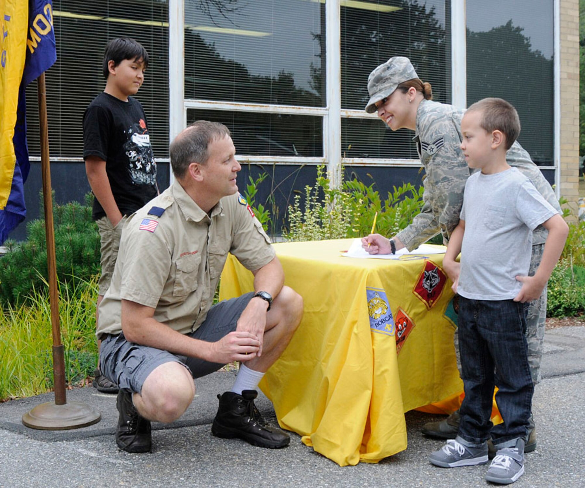HANSCOM AIR FORCE BASE, Mass. -- Boy Scout Troop Leader Peter Dugas discusses scouting with Jakeb Hernandez during the Hanscom Primary School "Meet and Greet" Aug. 29 outside the school. Incoming students from the primary and middle schools hosted the event as a way for parents and students to meet teachers, check class lists, purchase school spirit wear and find out more about the Parent Teacher Organization and Boy Scouts before the start of the new school year. (U.S. Air Force photo by Linda LaBonte Britt)
