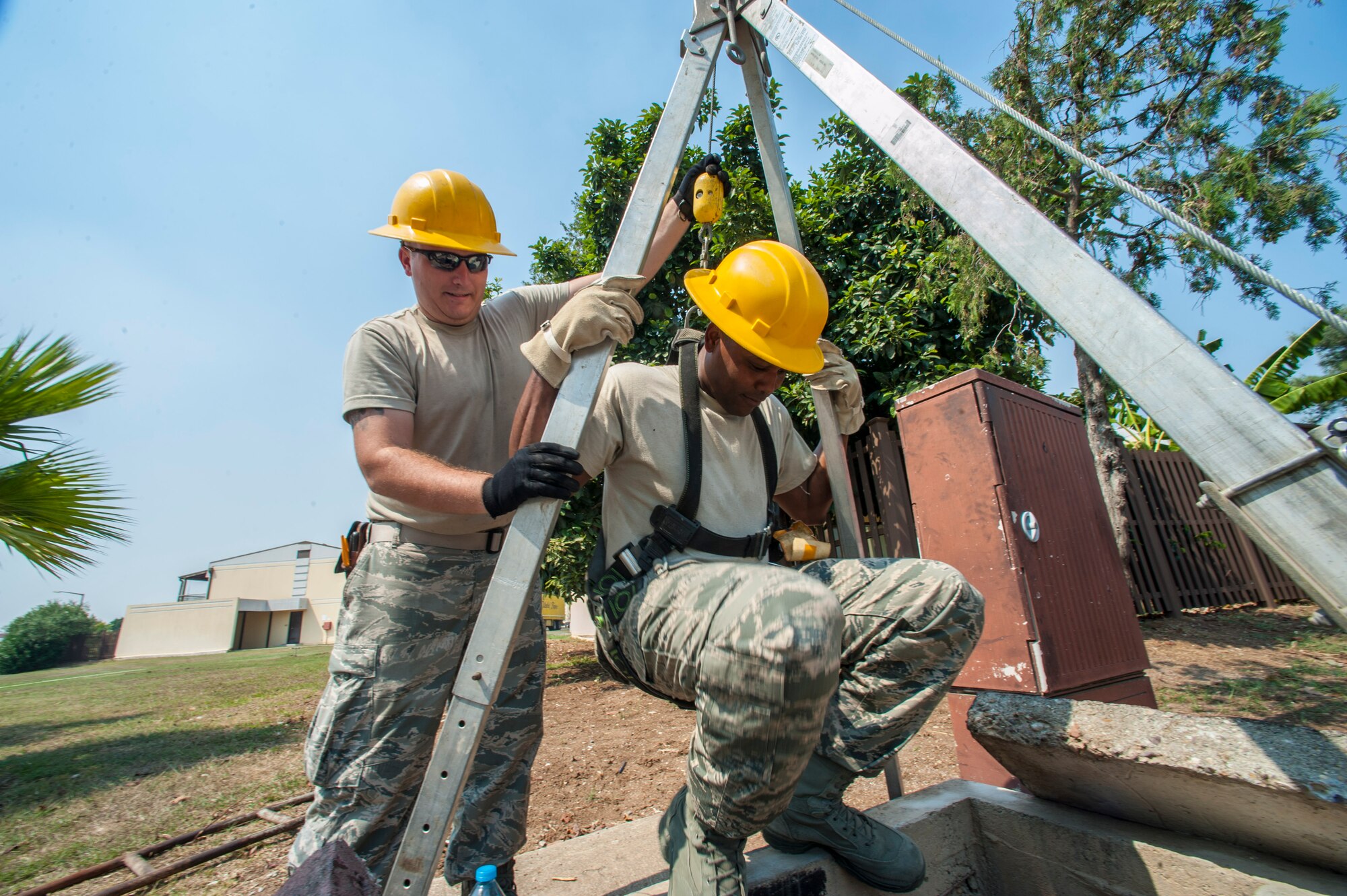 Senior Airman Albert Sikorski, 39th Communications Squadron cable and antenna maintenance technician, lowers Chief Master Sgt. Anthony Johnson, 39th Air Base Wing command chief into a manhole Aug. 29, 2013, at Incirlik Air Base, Turkey.  The 39th CS “cable dogs” taught Johnson and Col. Craig Wills, 39th ABW commander, how to cut and splice wires, as well as explained their daily duties. (U.S. Air Force photo by Airman 1st Class Nicole Sikorski/Released)