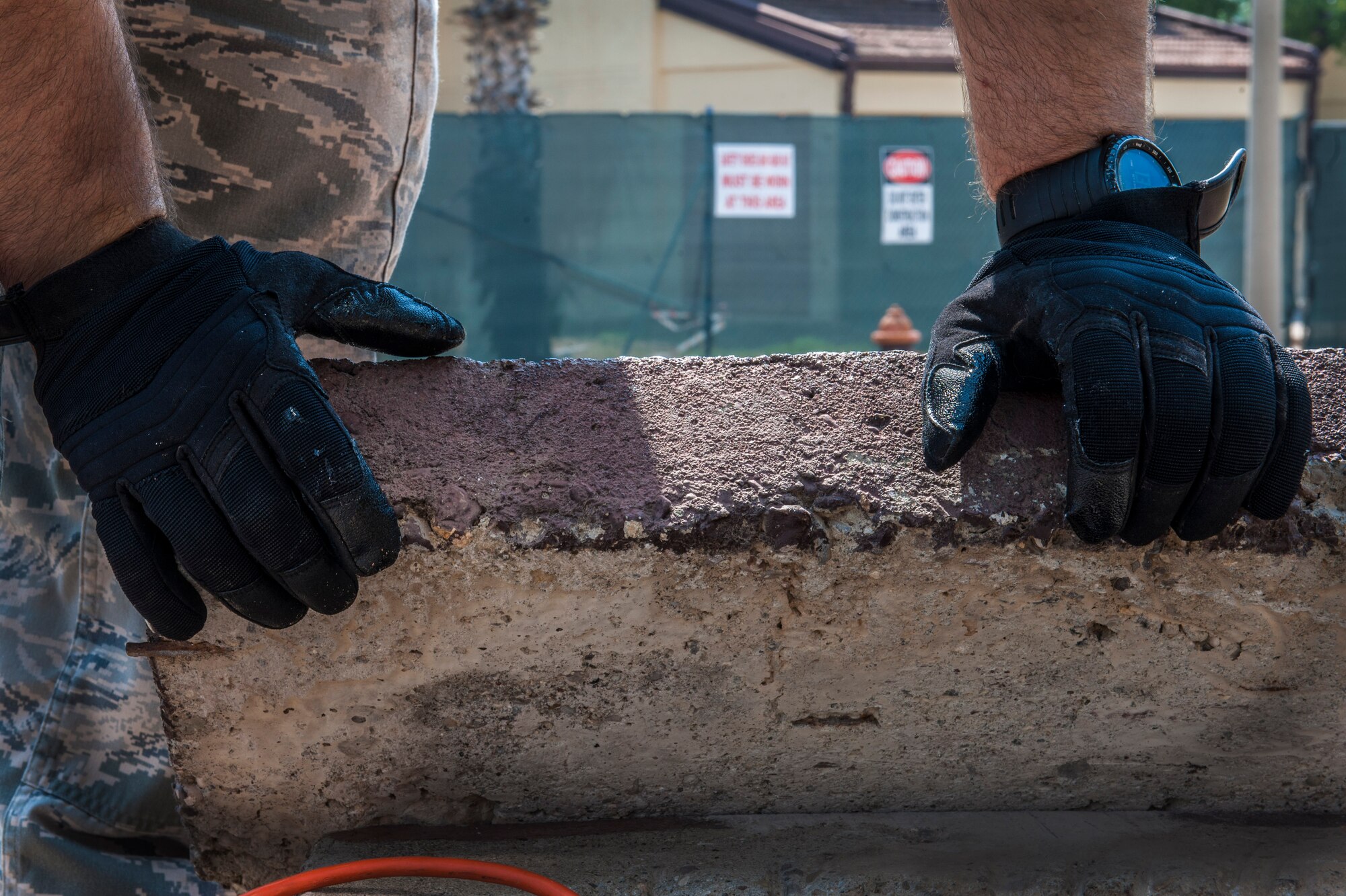 Senior Airman Albert Sikorski, 39th Communications Squadron cable and antenna maintenance technician, leans over a manhole cover while controlling the harness of his wingman Aug. 29, 2013, at Incirlik Air Base, Turkey.  The 39th CS “cable dogs” install manhole racks as well as ensure the integrity of cables on base. (U.S. Air Force photo by Airman 1st Class Nicole Sikorski/Released)