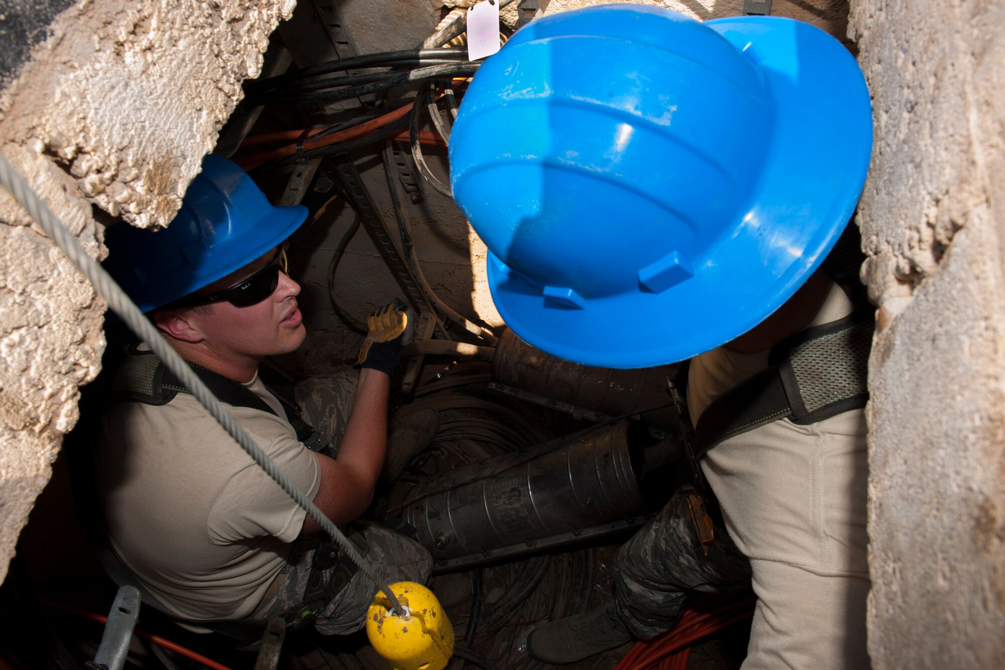Senior Airman Aaron Ellison, 39th Communications Squadron cable and antenna maintenance technician, explains his daily duties to Col. Craig Wills, 39th Air Base Wing commander Aug. 29, 2013, at Incirlik Air Base, Turkey.  The 39th CS “cable dogs” jump deep into manholes to ensure the integrity of fiber optics communications on base. (U.S. Air Force photo by Airman 1st Class Nicole Sikorski/Released)