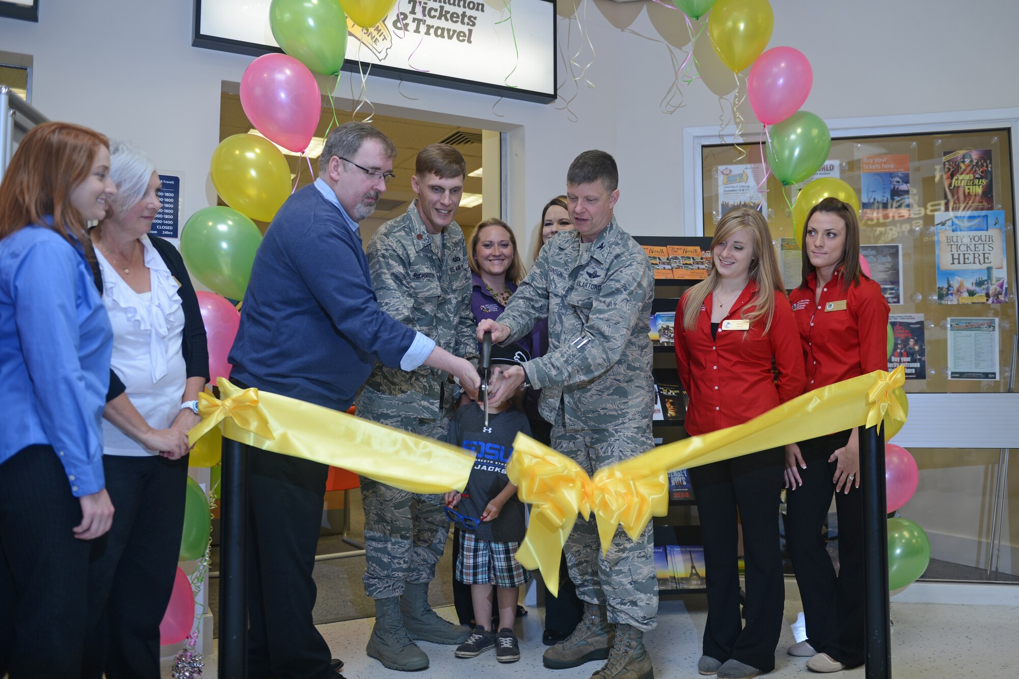 Col. Kyle Robinson (right), 48th Fighter Wing commander, Maj. Ryan Richardson (center), 48th Force Support Squadron commander, and Stephen Shaw, Army and Air Force Exchange Service store manager, cut a ribbon during the Information Tickets and Travel grand opening ceremony at Royal Air Force Lakenheath, England, Aug. 29, 2013. The ribbon-cutting ceremony celebrated the opening of the second ITT office inside the base Exchange. (U.S. Air Force photo by Airman 1st Class Trevor McBride/Released)