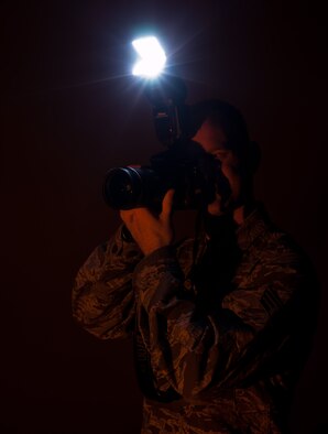 Senior Airman Clayton Lenhardt, 8th Fighter Wing Public Affairs photojournalist, conducts lighting tests inside the base studio at Kunsan Air Base, Republic of Korea, Sept. 5, 2013. Base leadership named Lenhardt as Kunsan’s “Pride of the Pack” for Aug. 19-25. (U.S. Air Force photo by Senior Airman Clayton Lenhardt / Released)