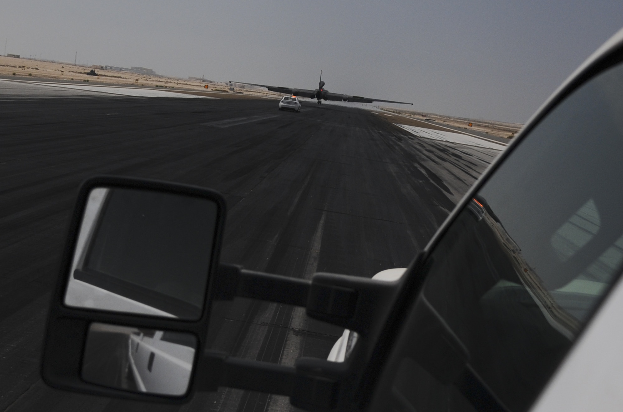 The auxillary landing gear, or pogo, team chases a U-2 Dragon Lady down the runway at an undisclosed location in Southwest Asia Aug. 27, 2013. The team is required to place an auxillary landing gear under each wing so the aircraft can taxi back to the hangar safely. (U.S. Air Force photo by Staff Sgt. Jacob Morgan)