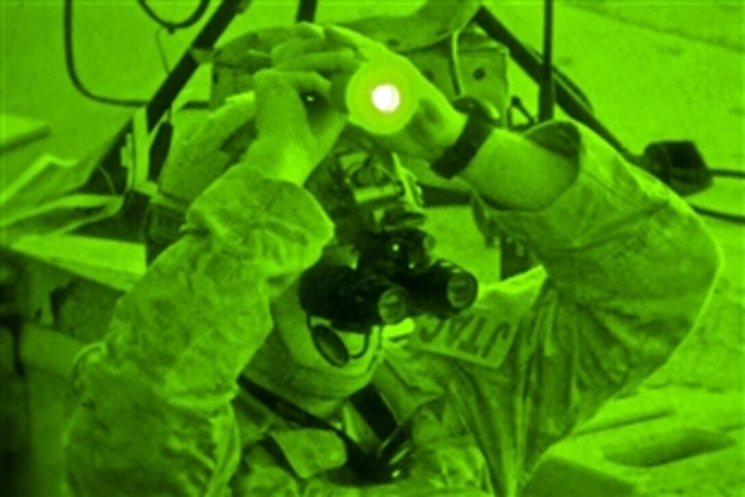 As seen through a night-vision device, Air Force Airman First Class Joshua Darins paints a target with a laser for an HH-60G Pave Hawk helicopter during live-fire training at Warren Grove Gunnery Range in Ocean County, N.J., Aug. 29, 2013. Darins, a tactical air control party airmen, is assigned to the New Jersey Air National Guard's 227th Air Support Operations Squadron, 177th Fighter Wing.