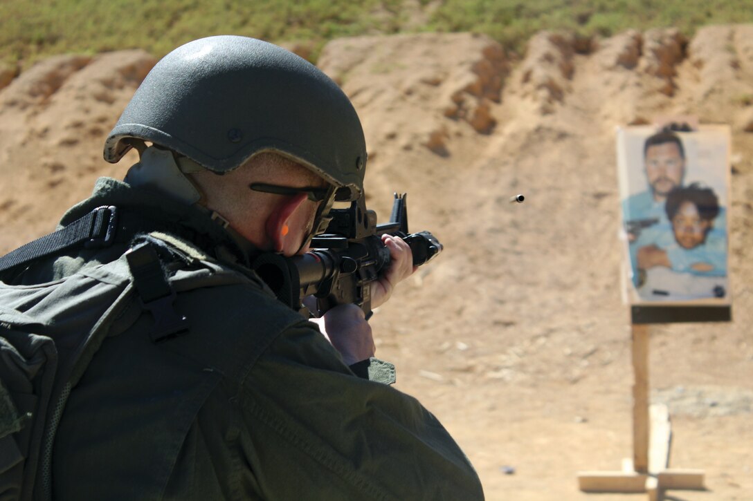 Staff Sgt. Jordan G. Hardy engages a simulated-hostage situation target with an M4 service rifle Aug. 27 at the battle-sight zero range on Camp Schwab. Scenario-based targets, including those based on hostage situations, were used to acclimate the Special Reaction Team members to performing professionally and efficiently in a high-stress environment. Hardy is the SRT platoon commander, Provost Marshal’s Office, Marine Corps Base Camp Smedley D. Butler, Marine Corps Installations Pacific.