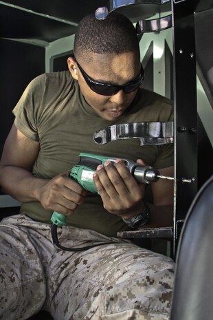 Cpl. Davion Carroll, Marine Wing Support Squadron 171 motor transportation mechanic, does maintenance work on a 7-ton truck in the MWSS-171 warehouse at Marine Corps Air Station Iwakuni, Japan, Aug. 21, 2013. With only a handful of Marines left in MWSS-171 motor-T, their hardest task is completing their usual workload with less people.