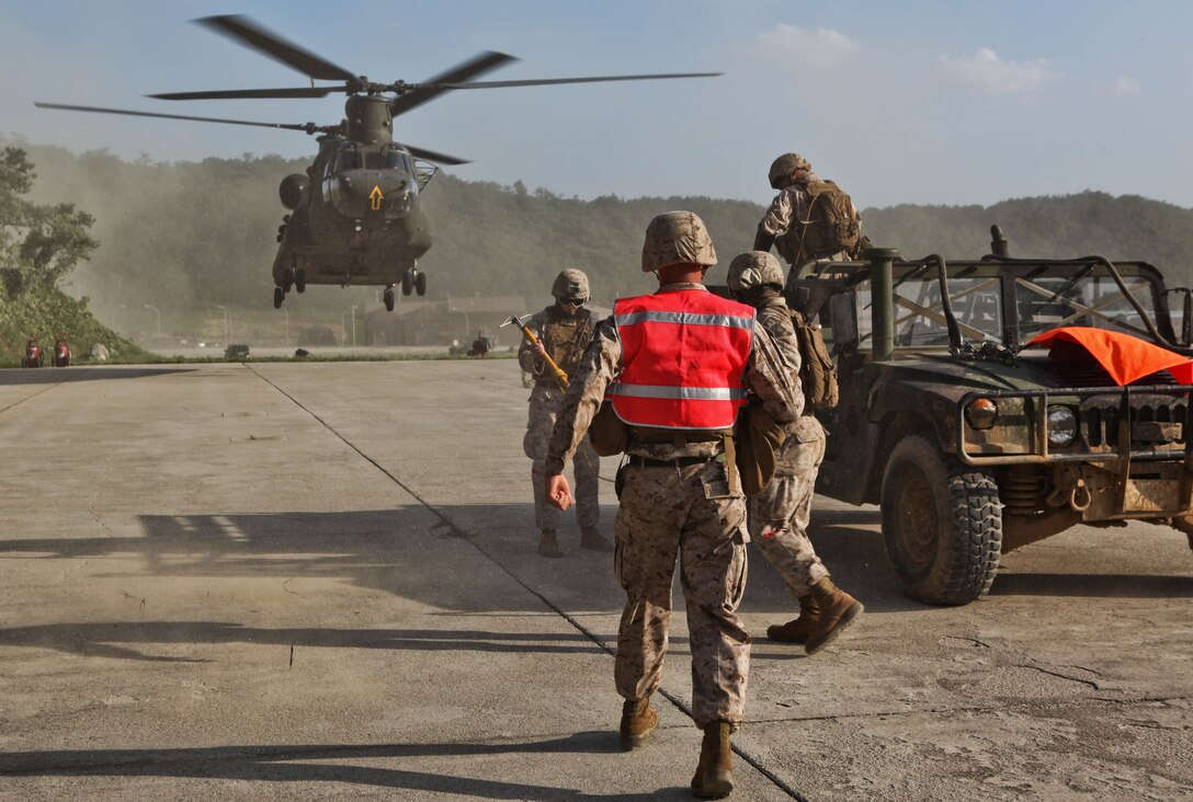 Marines prepare for an Army CH-47 Chinook helicopter’s landing before conducting joint, external-lift training at the Rodriguez Live-Fire Complex Aug. 19 as part of the Korean Marine Exchange Program 13-8. KMEP 13-8 is a combined, annual training exercise that enhances the combat readiness and interoperability of Republic of Korea and U.S. Marine Corps forces, promotes stability on the Korean Peninsula, and strengthens ROK and U.S. military capabilities. The CH-47 and its crew are with 3rd General Aviation Support Battalion, 2nd Aviation Regiment, 2nd Combat Aviation Brigade, 2nd Infantry Division. The Marines are with 3rd Battalion, 12th Marine Regiment, 3rd Marine Division, III Marine Expeditionary Force. 