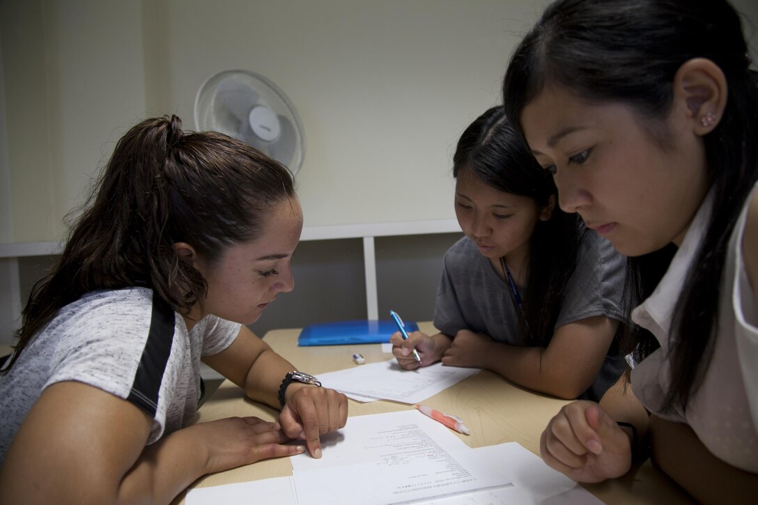 Pfc. Tracey Rodriguez, left, teaches English to Ao Nishino, center, and Anna Matayoshi Aug. 15 during the Camp Courtney English Camp. The camp, which lasted from Aug. 11–16, brings Uruma City students together with Marine volunteers to learn English and interact with one another. Rodriguez is a civil affairs noncommissioned officer with G-3, Civil Affairs, III Marine Expeditionary Force. 
