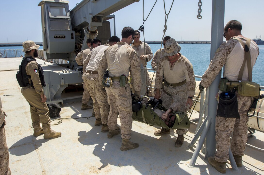 A U.S. Marine and a Special Amphibious Reconnaissance Corpsman assigned to Force Reconnaissance Platoon, Maritime Raid Force, 26th Marine Expeditionary Unit (MEU), demonstrate to foreign Marines how lower a casualty with a SKEDCO Sked System to a rigid hull inflatable boat during Maritime Interdiction Operations (MIO) training in the U.S. 5th Fleet area of responsibility, Aug. 28, 2013. The 26th MEU is a Marine Air-Ground Task Force forward-deployed to the U.S. 5th Fleet area of responsibility aboard the Kearsarge Amphibious Ready Group serving as a sea-based, expeditionary crisis response force capable of conducting amphibious operations across the full range of military operations. (U.S. Marine Corps photo by Sgt. Christopher Q. Stone, 26th MEU Combat Camera/Released)