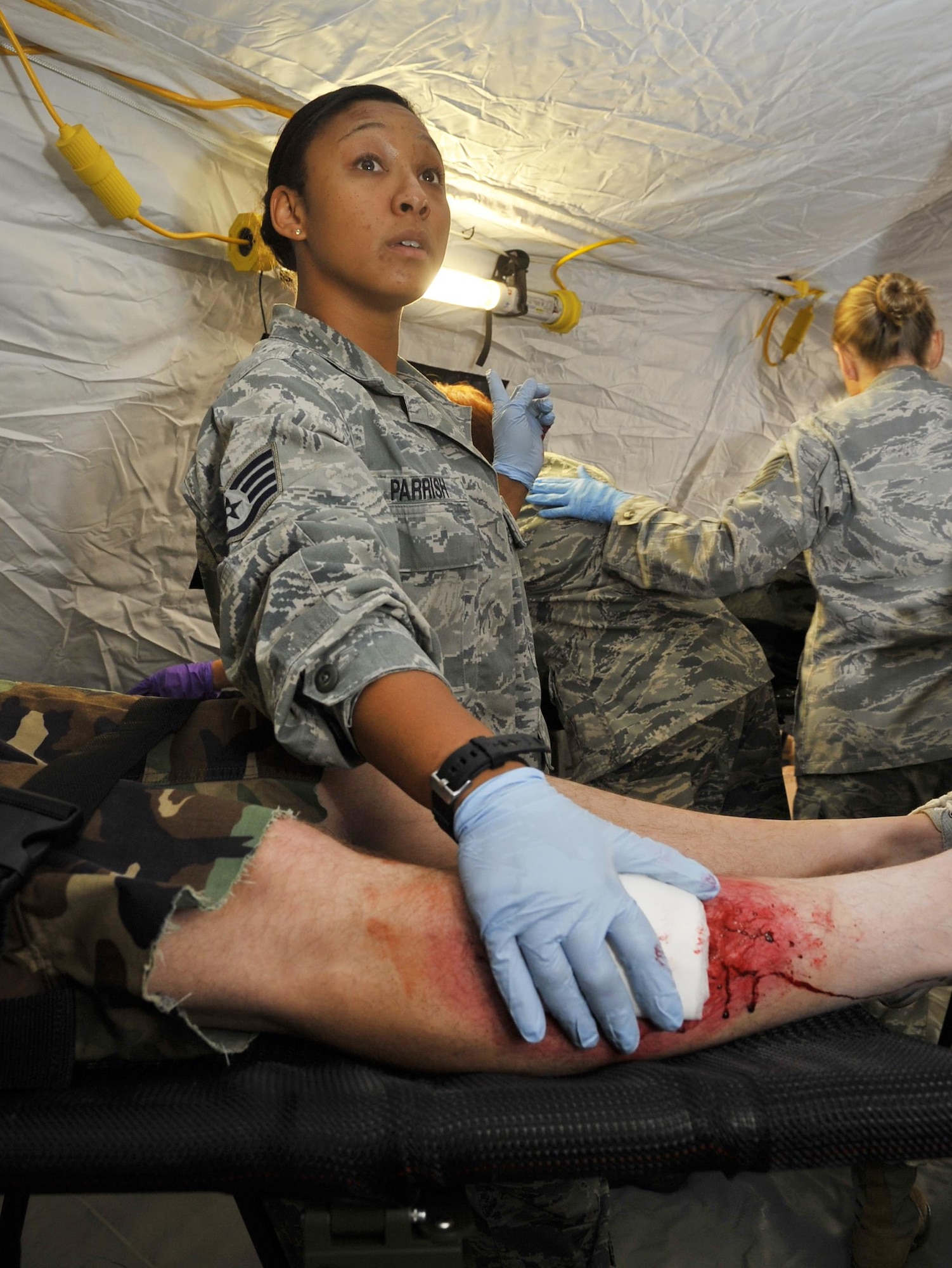 An U.S. Air Forces in Europe and Air Forces Africa medical unit member patches up the leg of a wounded patient during expeditionary medical support training Aug. 28, 2013, at Ramstein Air Base, Germany. EMEDS training is conducted to prepare Airmen for humanitarian missions. (U.S. Air Force photo/Airman Dymekre Allen) 