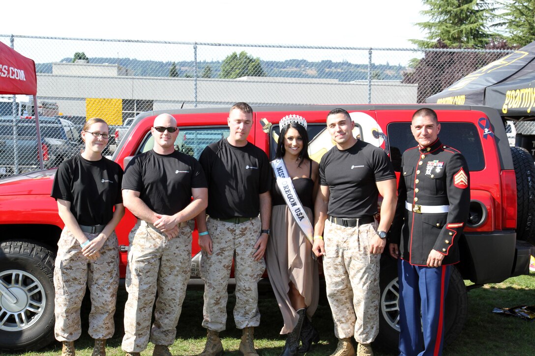 Gabrielle Neilan, Miss Oregon USA, takes a photo with Marines from Recruiting Station Portland, 12th Marine Corps District, during a Marine Corps pull-up challenge at Oregon Jamboree Music Festival in Sweet Home, Ore., Aug., 2. Participants receive Marine Corps gear for pull-ups successfully completed.