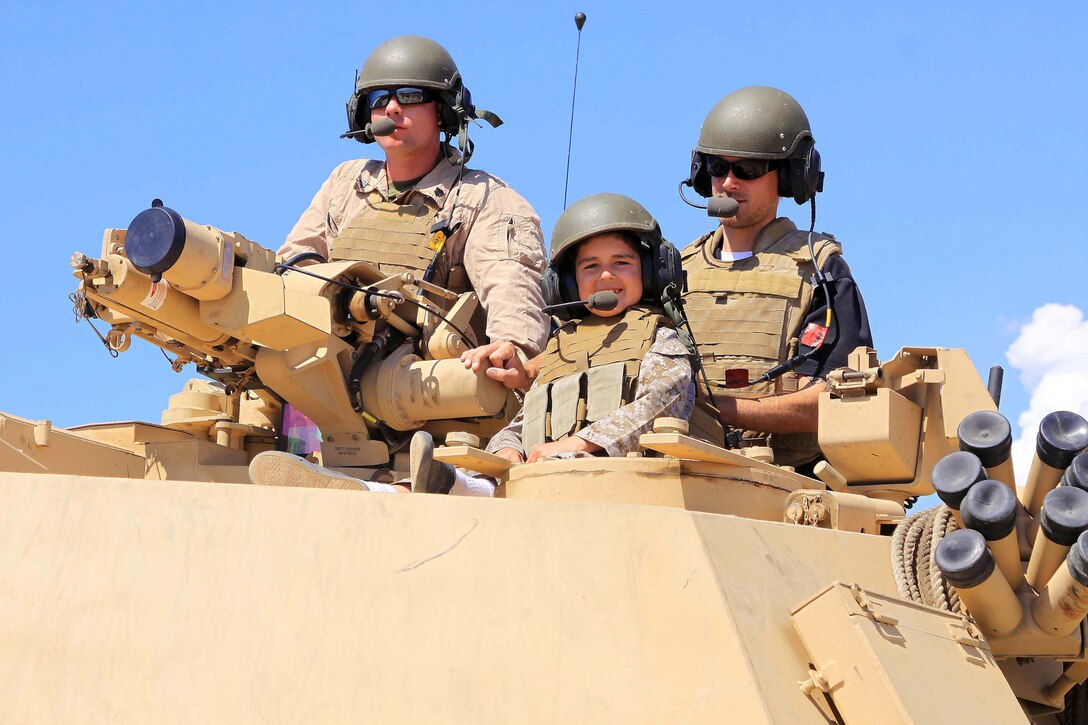 Baden, center, and his father, Chris Mayo, right, ride on a tank during their visit to Camp Pendleton Sept. 4. 7-year-old Baden was diagnosed with Acute Lymphoblastic Leukemia December 10, 2010 when he was 5-years-old. After a little over a year of intensive chemotherapy he was declared in remission, but unfortunately during one of his routine clinics doctors found that leukemia was back in his spinal fluid. Charity for Charity worked with Marines from Camp Pendleton to make Badens dream of riding a tank come true.
