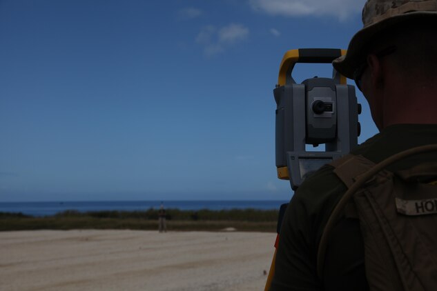 Marines with Marine Wing Support Squadron 172 use surveyor's equipment to examine a piece of land Aug. 28 during construction of a new landing pad at Ie Shima training facility. The pads, intended to support helicopter and MV-22B Osprey tiltrotor training, must be perfectly flat and hold a specific gradient. MWSS 172 is part Marine Aircraft Group 36, 1st Marine Air Wing, III Marine Expeditionary Force. 