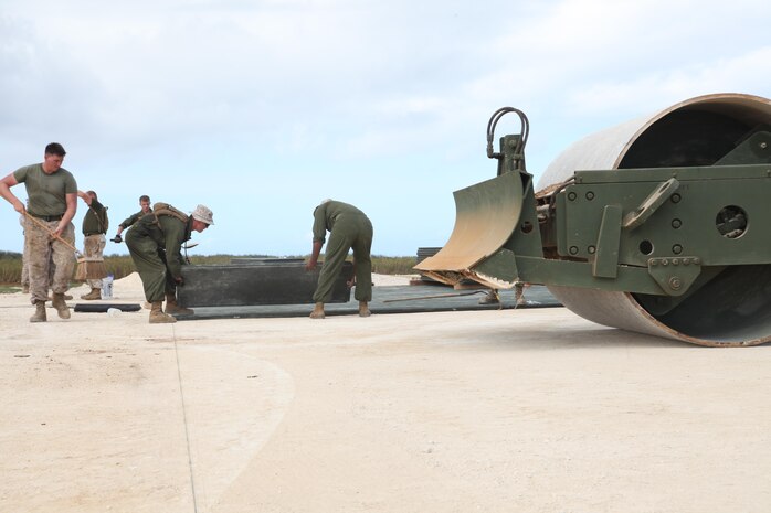 Service members with Marine Wing Support Squadron 172 place landing pads into position Aug. 28 at Ie Shima training facility. The landing areas are completed when the top layer of the area, called AM-2 pad surface, is successfully laid on top of the prepared surface, creating a safe and durable landing zone for rotary-wing aircraft such as helicopters and MV-22B Osprey tiltrotor aircraft. The landing area at Ie Shima is expected to increase III Marine Expeditionary Force’s unit capabilities for training and operations, according to Master Sgt. Juan C. Manco, the staff noncommissioned officer in charge for expeditionary airfields with MWSS 172, Marine Aircraft Group 36, 1st Marine Air Wing, III Marine Expeditionary Force. 