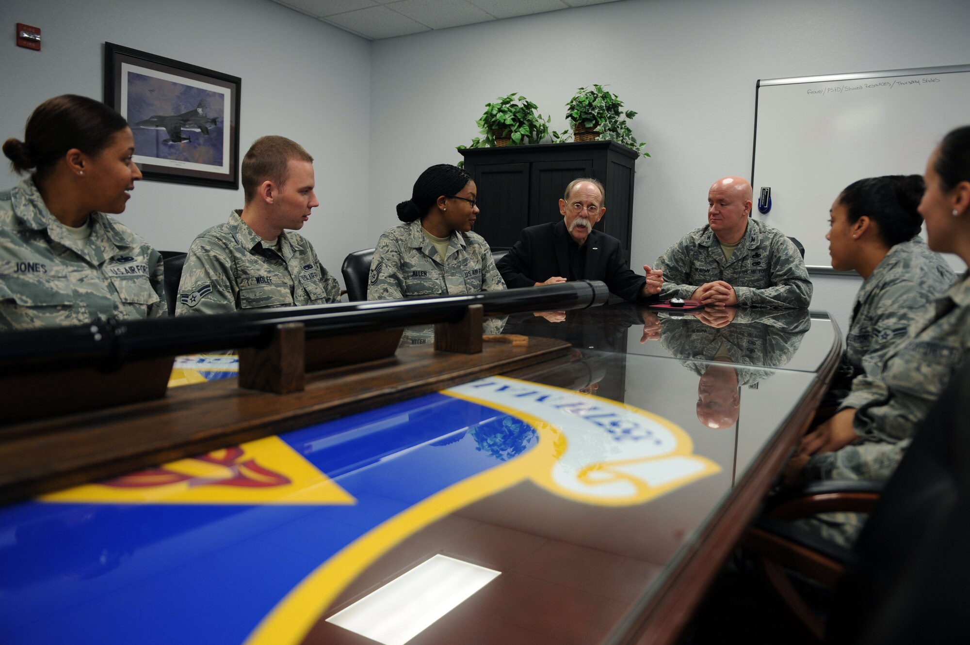 U.S. Air Force Airmen from the 355th Maintenance Group sit with John Eslinger, 355th MXG honorary commander, as they discuss an upcoming group event at Davis-Monthan Air Force Base, Ariz., Sept. 5, 2013. The intent of D-M's Honorary Commander program is to educate community leaders on the inner workings of the base and the Air Force as a whole. (U.S. Air Force photo by Airman 1st Class Saphfire Cook/Released) (cropped)