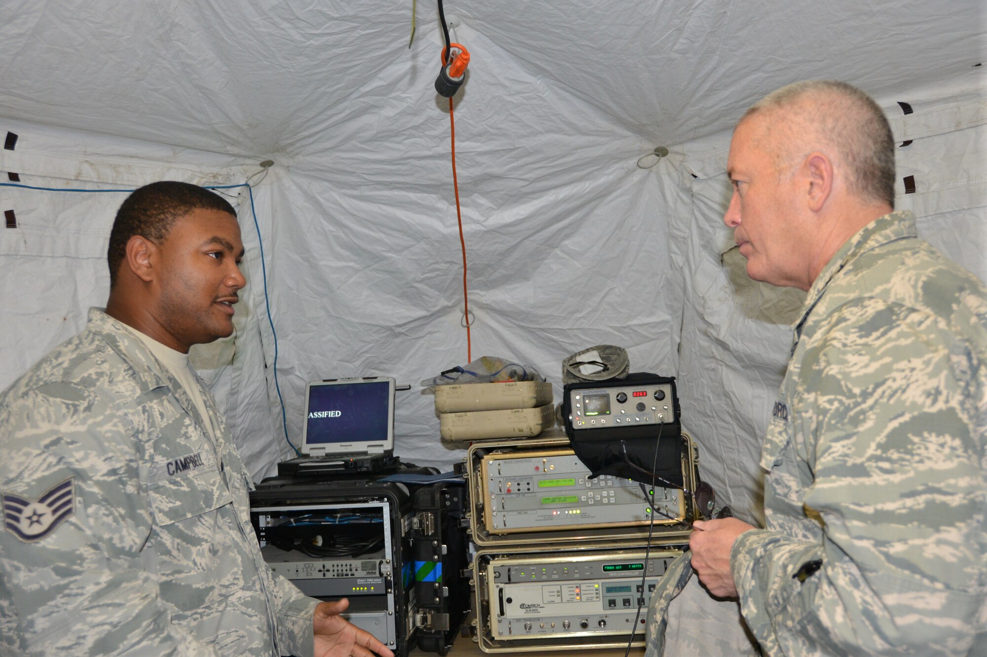 Staff Sgt. Dominique Campbell, a radio frequency craftsman with the 5th Combat Communications Group, discusses a satellite communication suite with Lt. Gen. William Etter, commander, Air  Forces Northern. The suite enables users voice and data transmissions in a contingency environment. U.S. Air Force photo by Mary McHale