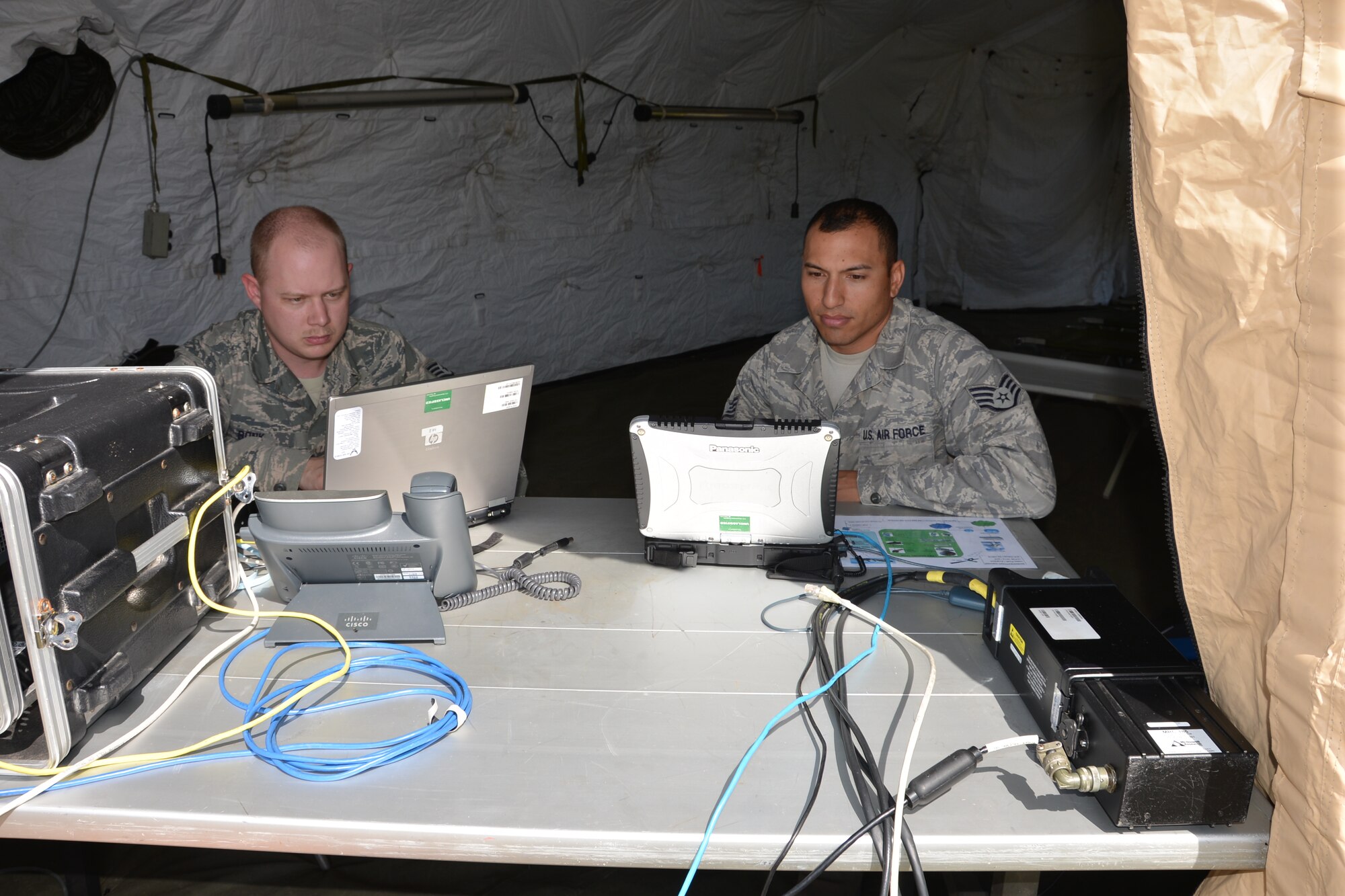Staff Sgt. Evan Bonk, a cyber transportation craftsman and Staff Sgt. Jeff Rybold, a radio frequency transmission systems craftsman, both of the 5th Combat Communications Group, check out equipment used to work with full motion video imagery. Such imagery allows better situational awareness for responders and commanders during contingency operations. U.S. Air Force by Mary McHale