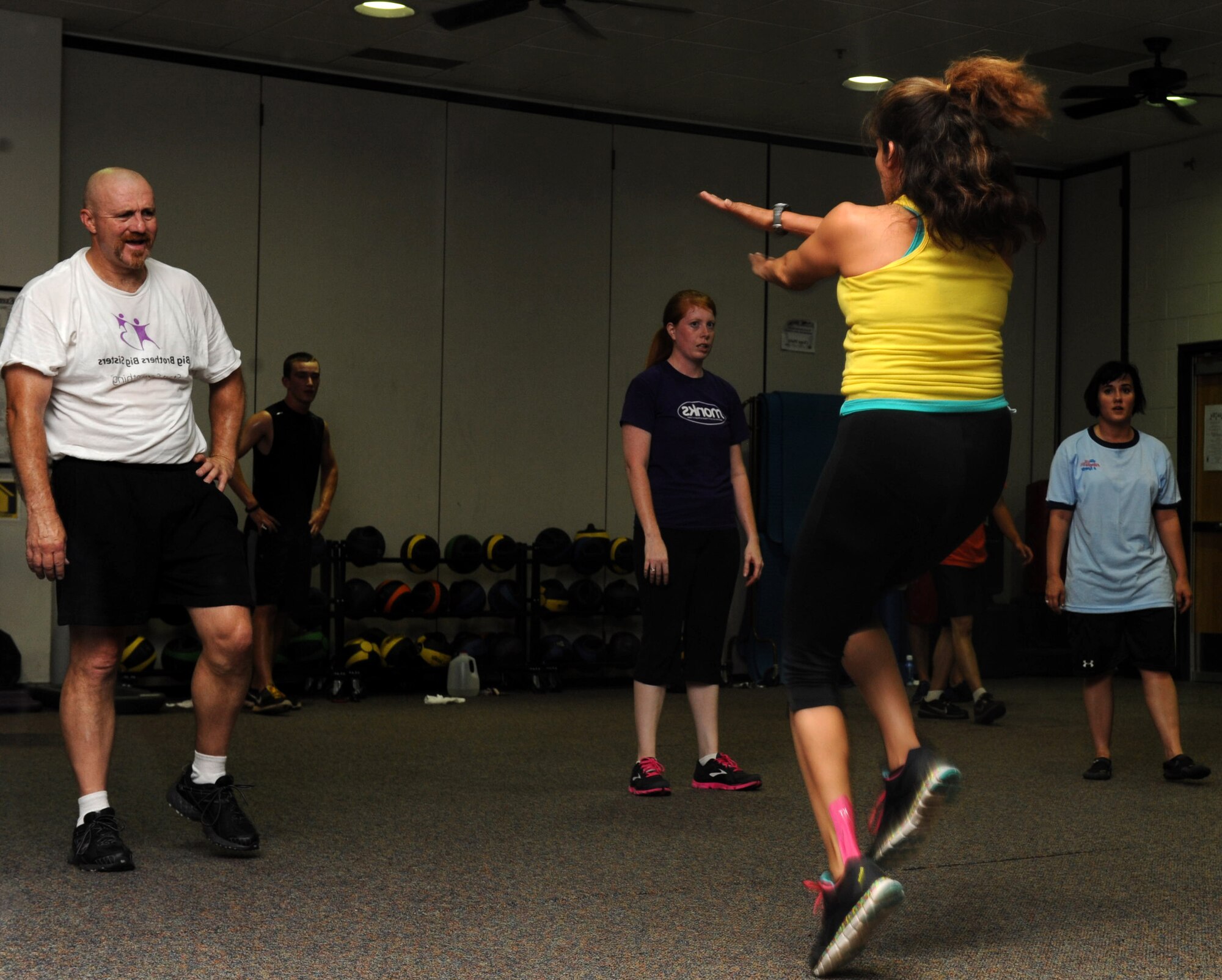 Penny Vieau, a Dyess Fitness Center Insanity instructor, shows participants how to execute an exercise during the new Insanity class at the Dyess Fitness Center Aug. 27, 2013. The workout class is derived from the Insanity fitness program, which is traditionally a 60-day DVD led workout.(U.S. Air Force photo by Airman Autumn Velez/Released)