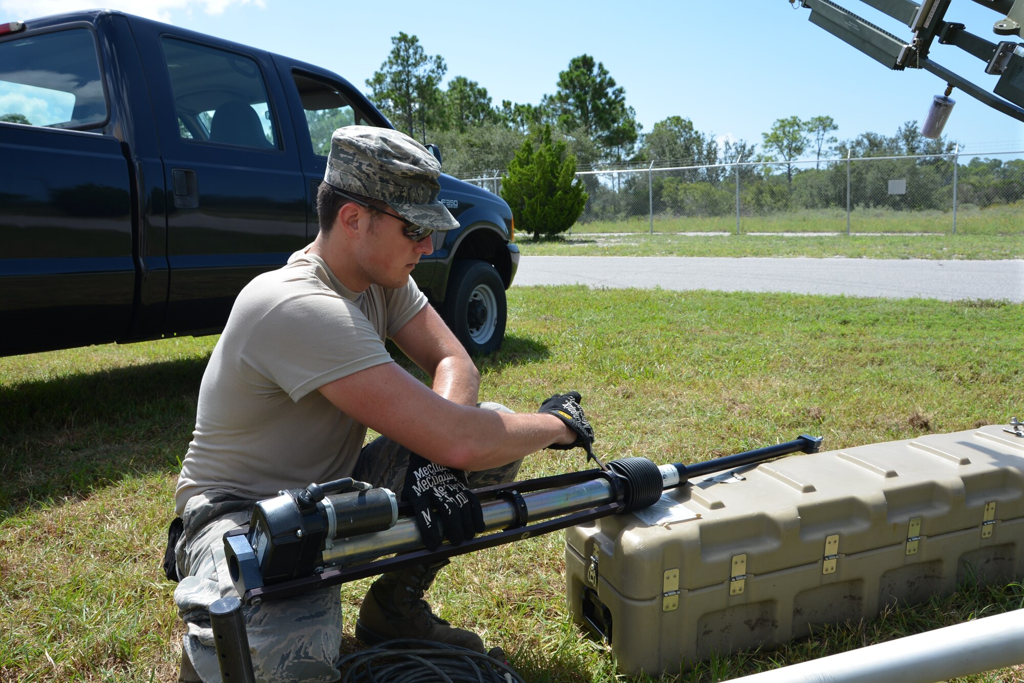 Airman 1st Class Alexander Riggs, a radio frequency transmission systems journeyman with the 5th Combat Communications Group, adjusts a satellite arm prior to fitting on the device. In the field , the satellite is key to transmitting necessary signals to help the communications suites operate. U.S. Air Force photo by Mary McHale