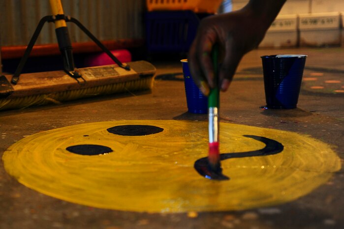 Senior Airman Poly-Bess Nagbe, 628th Aerial Medical Squadron, health service management paints a floor during the Day of Caring event Sep. 6, 2013, at the Children's Museum of the Low Country in Charleston, S.C. Approximately 2,500 service members from JB Charleston participated in the Day of Caring, volunteering their skills to assist with more than 50 projects in the local community. The base held their volunteer events a week earlier than Trident United Way's Day of Caring, due to events surrounding the delivery of the final U.S. Air Force C-17 Globemaster III.   (U.S. Air Force photo/ Airman 1st Class Chacarra Neal)