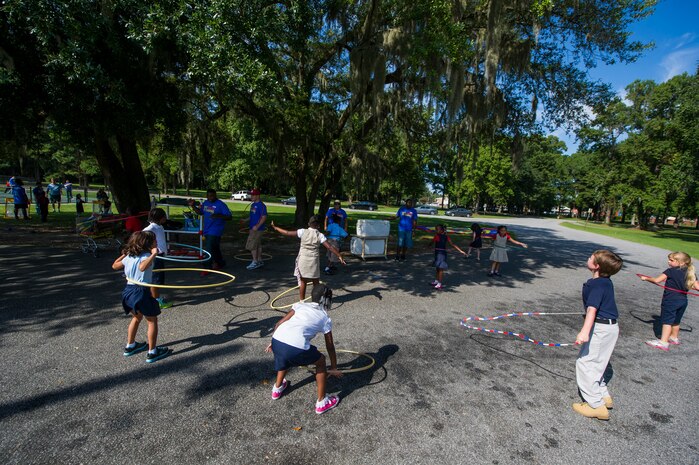 Joint Base Charleston Airmen instruct students on hula hoops during the Military Day of Caring Sept. 6, 2013, at Lambs Elementary School, Charleston, S.C. Approximately 2,500 service members from JB Charleston participated in the Day of Caring, volunteering their skills to assist with more than 50 projects in the local community. The base held their volunteer events a week earlier than Trident United Way's Day of Caring, due to events surrounding the delivery of the final U.S. Air Force C-17 Globemaster III.   (U.S. Air Force photo/ Senior Airman George Goslin)