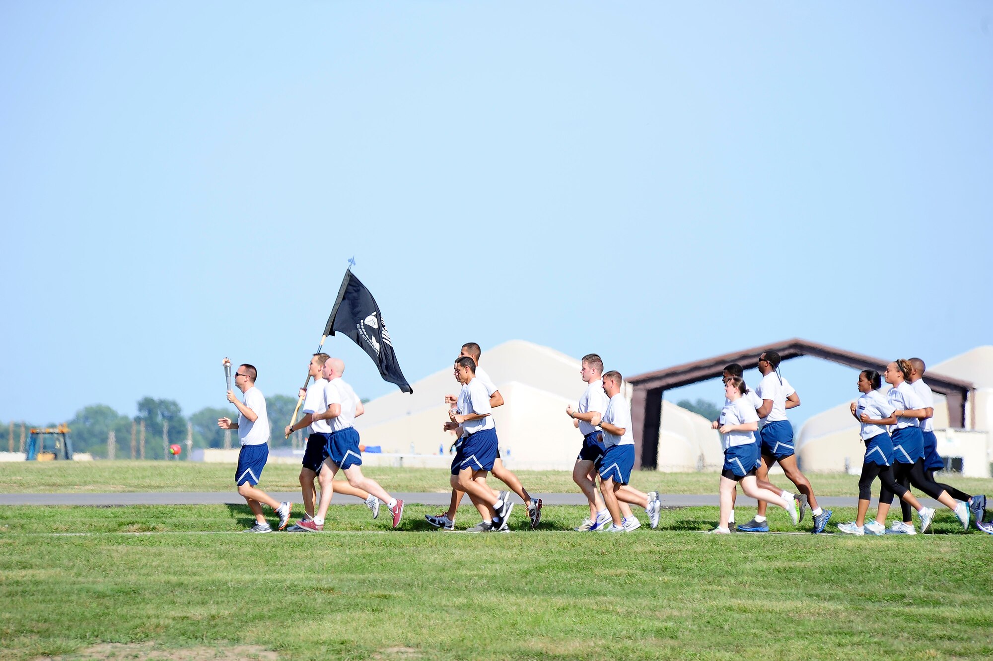 Members from the 509th Comptroller Squadron and Wing Staff Agencies kickoff the 24-hour memorial run in honor of those listed as prisoners of war and missing in action remembrance ceremony, Sept. 5, 2013, at Whiteman Air Force Base, Mo. Throughout the run, squadrons took turns carrying the lit torch and POW/MIA flag. (U.S. Air Force photo by Staff Sgt. Brigitte N. Brantley/Released)