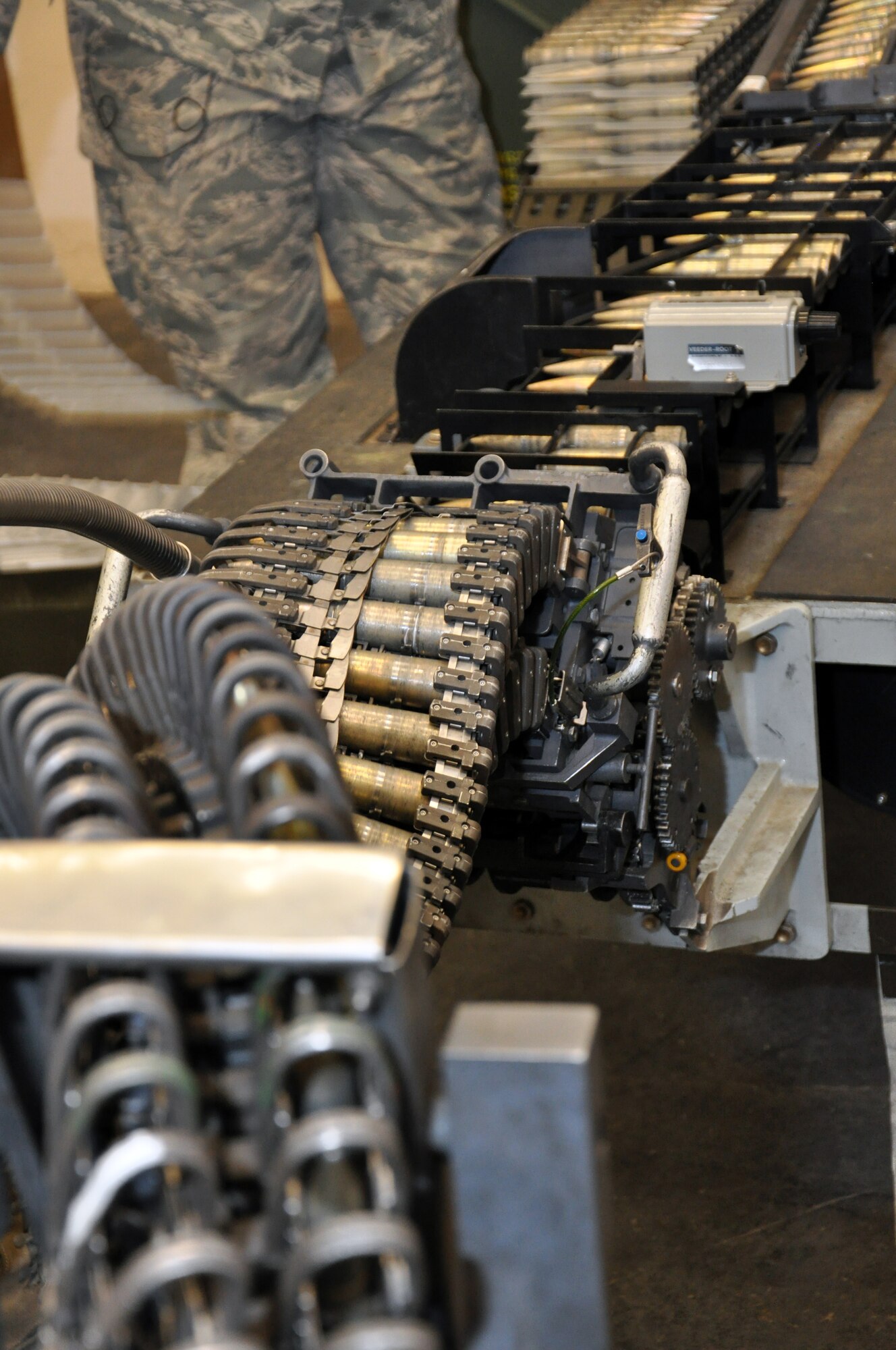 After being put on the 20mm ammunition loading table, rounds travel down the snaking belt into the Universal Ammunition Loading System Aug. 1, 2013, on Buckley Air Force Base, Colo. The UALS hold 1,525 rounds of 20mm ammunition used by F-16 Fighting Falcons. The 140th Wing handles the munitions needs of units across the Front Range. (U.S. Air Force photo by Staff Sgt. Nicholas Rau/Released)