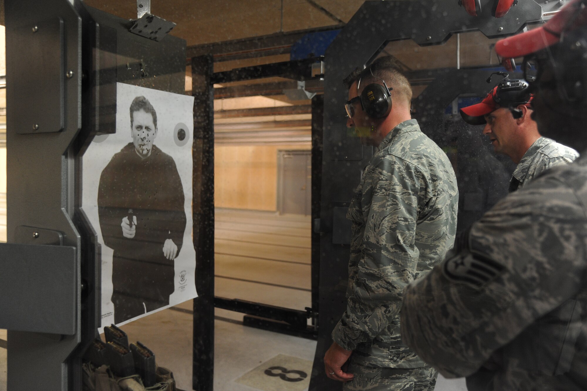 Brig. Gen. Patrick Higby, 81st Training Wing commander, examines his target with the assistance of Tech. Sgt. Jonathan Johnson, 81st Security Forces Squadron, while touring the 81st Security Forces Squadron indoor firing range during an immersion tour of the 81st Mission Support Group Sept. 4, 2013, at Keesler Air Force Base, Miss. The purpose of the tour was to learn the integration of the group operations and personnel.  (U.S. Air Force photo by Kemberly Groue)