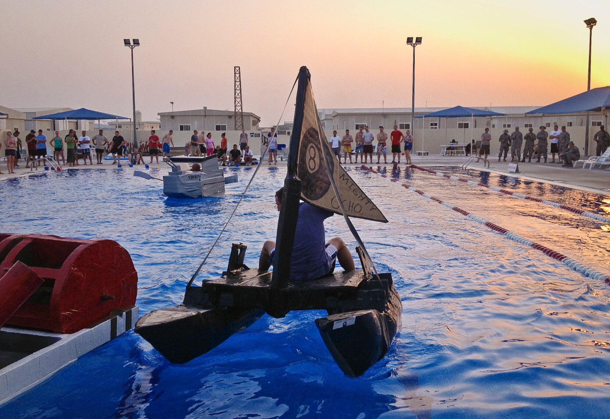 Grand Slam service members participate in a cardboard boat regatta heralding the end of summer in the base pool at the 379th Air Expeditionary Wing in Southwest Asia, Sept. 1, 2013. The winning team is from the 8th Expeditionary Air Mobility Squadron’s passenger terminal. Their team name was “Thee Ocho Pearl.” (U.S. Air Force photo/Patti Gibbs)