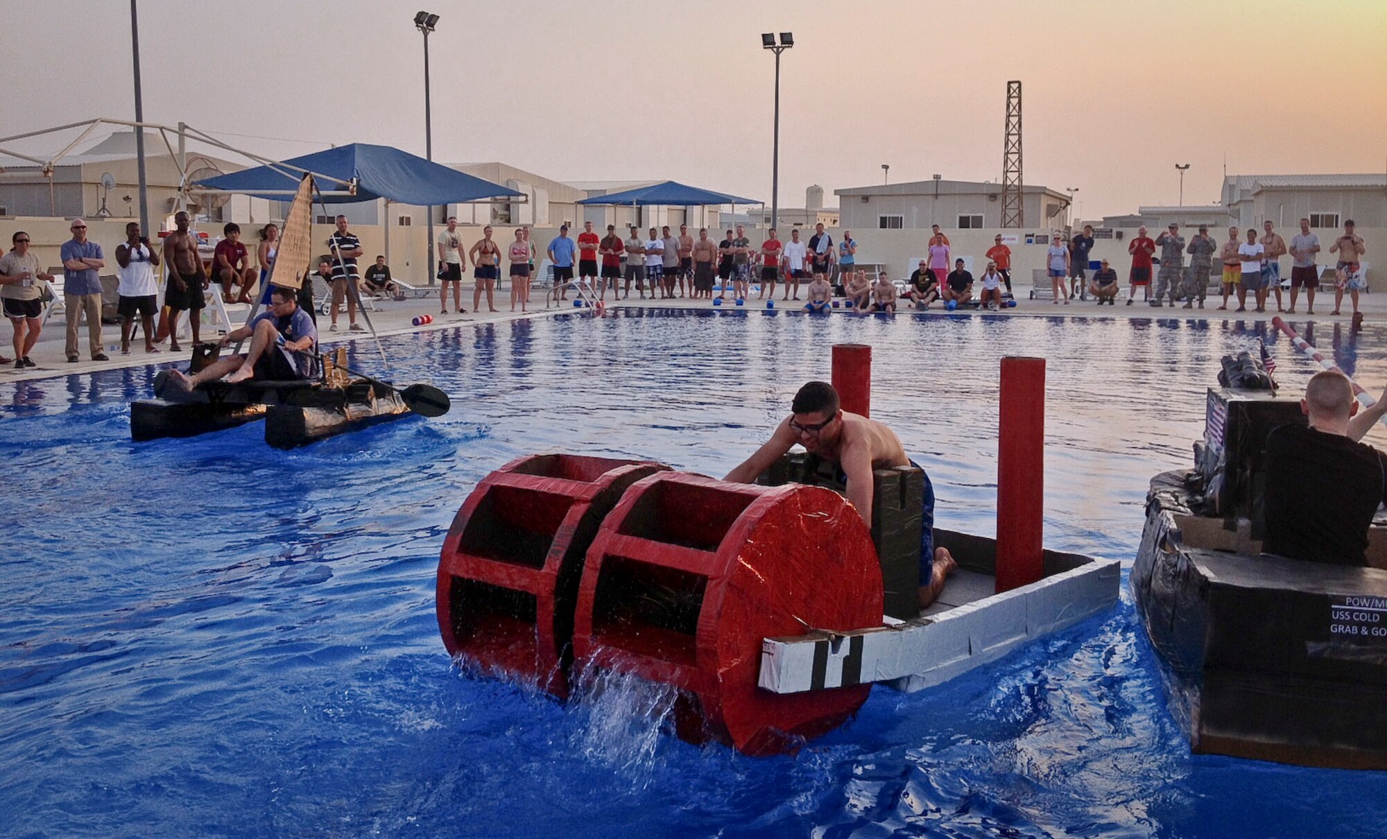 Grand Slam service members participate in a cardboard boat regatta heralding the end of summer in the base pool at the 379th Air Expeditionary Wing in Southwest Asia, Sept. 1, 2013. The winning team is from the 8th Expeditionary Air Mobility Squadron’s passenger terminal. Their team name was “Thee Ocho Pearl.” (U.S. Air Force photo/Patti Gibbs)