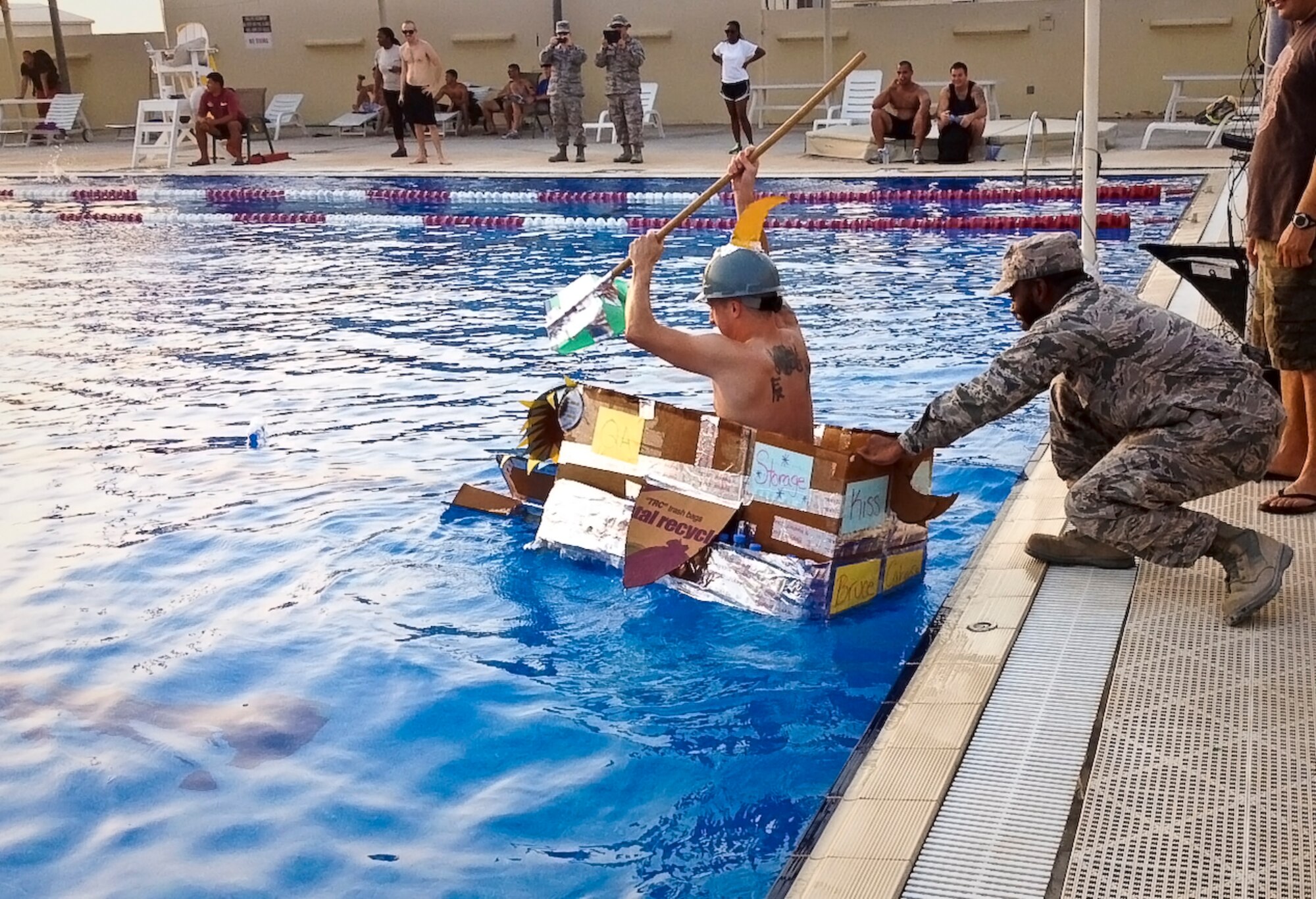 Grand Slam service members participate in a cardboard boat regatta heralding the end of summer in the base pool at the 379th Air Expeditionary Wing in Southwest Asia, Sept. 1, 2013. These regattas started last year and are held periodically, depending on holiday themes. (U.S. Air Force photo/Patti Gibbs)