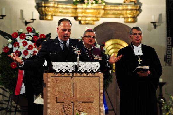 Maj. Michael Curtis, 435th Air Ground Operations Wing chaplain, prays during a commemoration of the Flugtag ’88 accident Aug. 28, 2013, at St. Nikolaus church, Raimstein-Miesenbach, Germany. During the last scheduled air show 25 years ago on this day, three Italian aircraft collided while attempting to enact the "Pierced heart" maneuver. (U.S. Air Force photo/Senior Airman Hailey Haux)