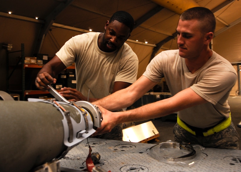 Staff Sgt. Everett Myles and Airman 1st Class Matthew Carlson install a sensor on a laser joint directed attack munition during a bomb build at the 379th Air Expeditionary Wing in Southwest Asia, Sept. 2, 2013. The sensor is what guides the bomb once it is deployed from the aircraft. Myles is a 379th Expeditionary Maintenance Squadron conventional maintenance crew chief and hails from Fort Worth, Texas. Carlson is a 379th Expeditionary Maintenance Squadron conventional maintenance crew member and a Lake Panasoffkee, Fla., native. Both are deployed from Dyess Air Force Base, Texas. (U.S. Air Force photo/Senior Airman Bahja J. Jones) 