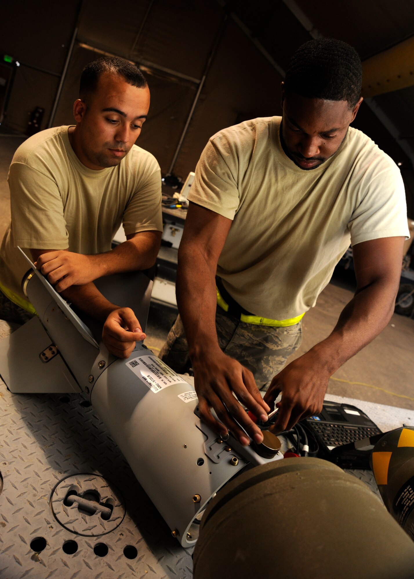 Senior Airman Jesse Bermudez and Staff Sgt. Everett Myles prepare the fin on a laser joint directed attack munition during a bomb build at the 379th Air Expeditionary Wing in Southwest Asia, Sept. 2, 2013. Bermudez is a 379th Expeditionary Maintenance Squadron conventional maintenance crew member and a San Antonio native. Myles is a 379th EMXS conventional maintenance crew chief and hails from Fort Worth, Texas. Both are deployed from Dyess Air Force Base, Texas. (U.S. Air Force photo/Senior Airman Bahja J. Jones) 