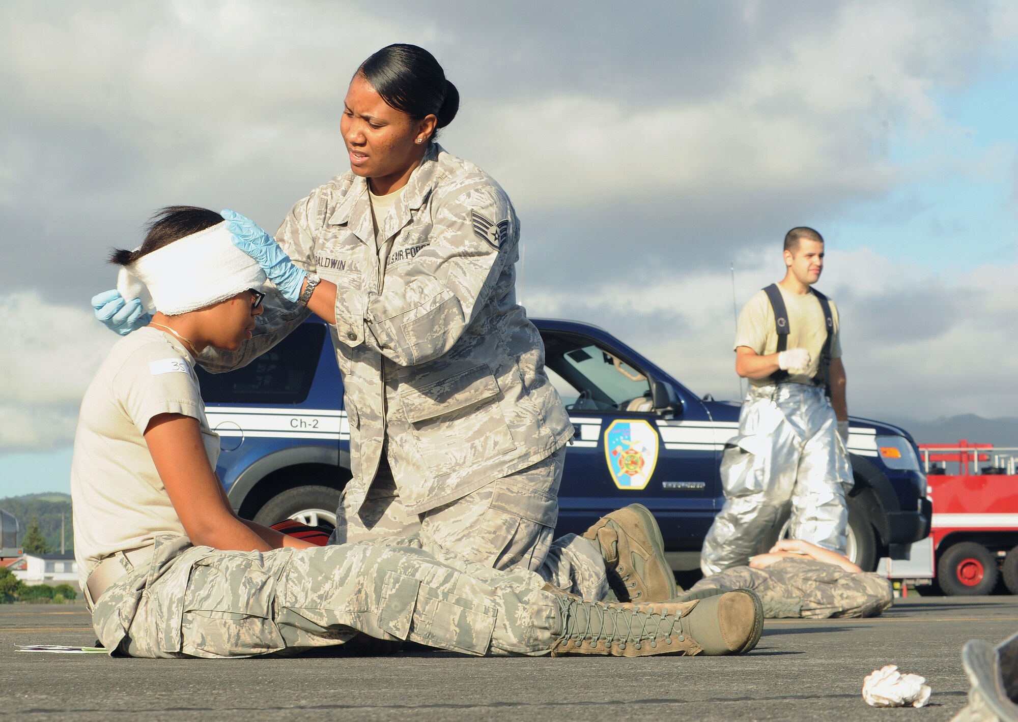U.S. Air Force Staff Sgt. Yvette Baldwin, 65th Medical Operations Squadron medical technician, gives first aid to a mock victim during a major accident response exercise Aug. 23, 2013, at Lajes Field, Azores.  Baldwin is the NCOIC of flight medicine at Lajes Field, and is responsible for the care of Lajes' air traffic controllers and other Airmen whose day-to-day activities include occupational hazards.  (U.S. Air Force photo by Guido Melo/Released)
