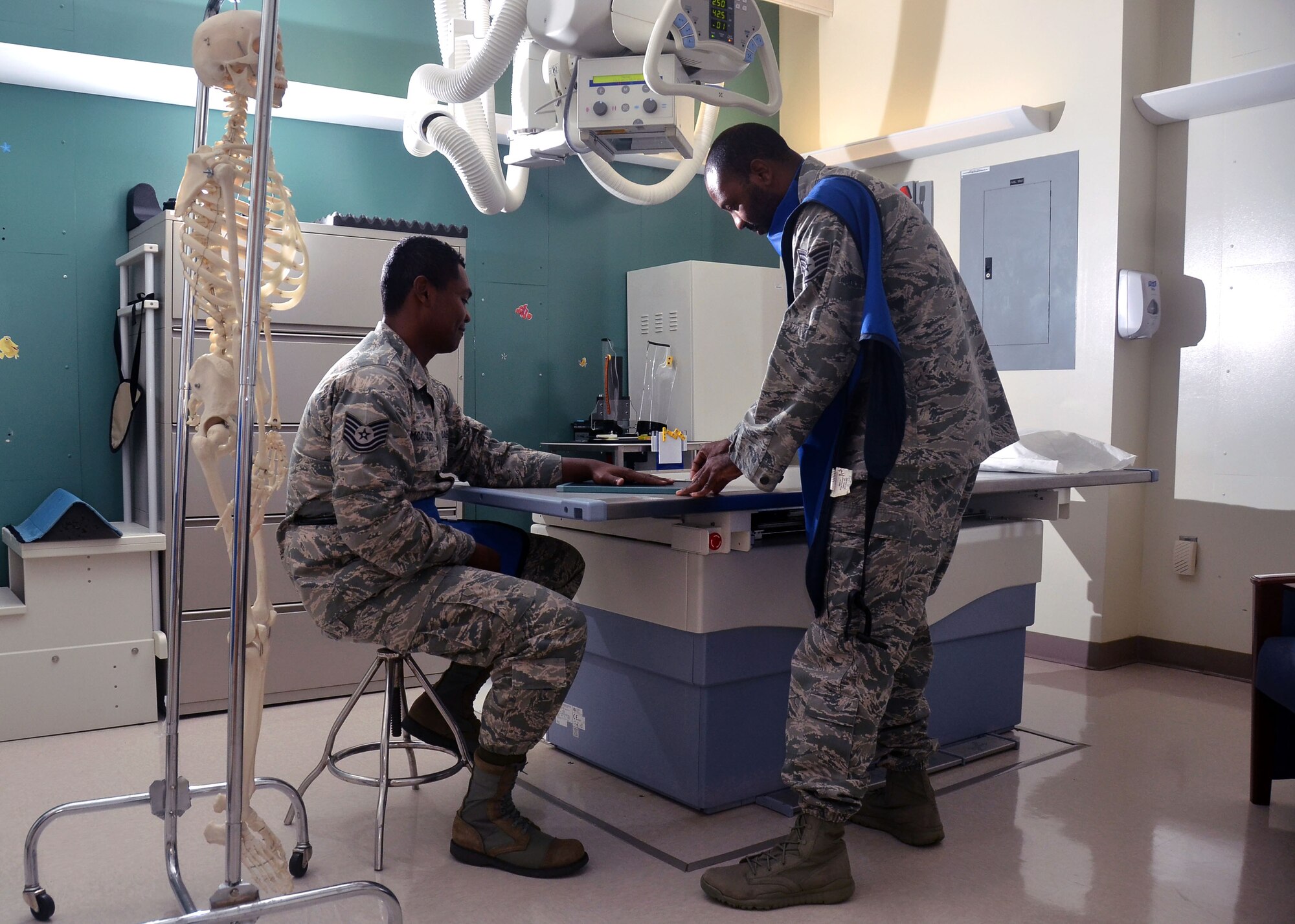 Staff Sgt. Jahmal Nicholas (right), 36th Medical Support Squadron NCO in charge of diagnostics imaging, positions Tech. Sgt. JJ McCloud, 36th MDSS diagnostic and therapeutic flight chief, for a posterior anterior hand x-ray during training Aug. 4, 2013, on Andersen Air Force Base, Guam.  A doctor will typically start in-depth testing with a standard X-ray, but will rely on a CT scan or an MRI depending on the results. (U.S. Air Force photo by Airman 1st Class Mariah Haddenham/Released)