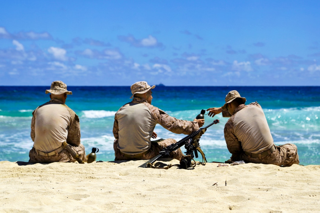 Marines enjoy a moment of relaxation on a beach after conducting an amphibious training raid as part of Tropic Thunder, an exercise on Marine Corps Base Hawaii, Kaneohe Bay, Hawaii, Aug. 30, 2013.